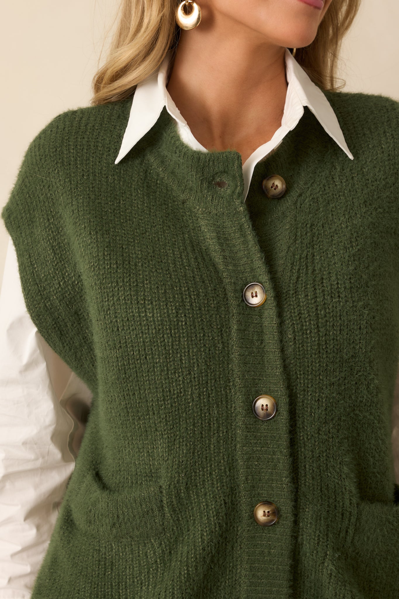 Close-up showing the knit fabric, buttons, and patch pocket construction.