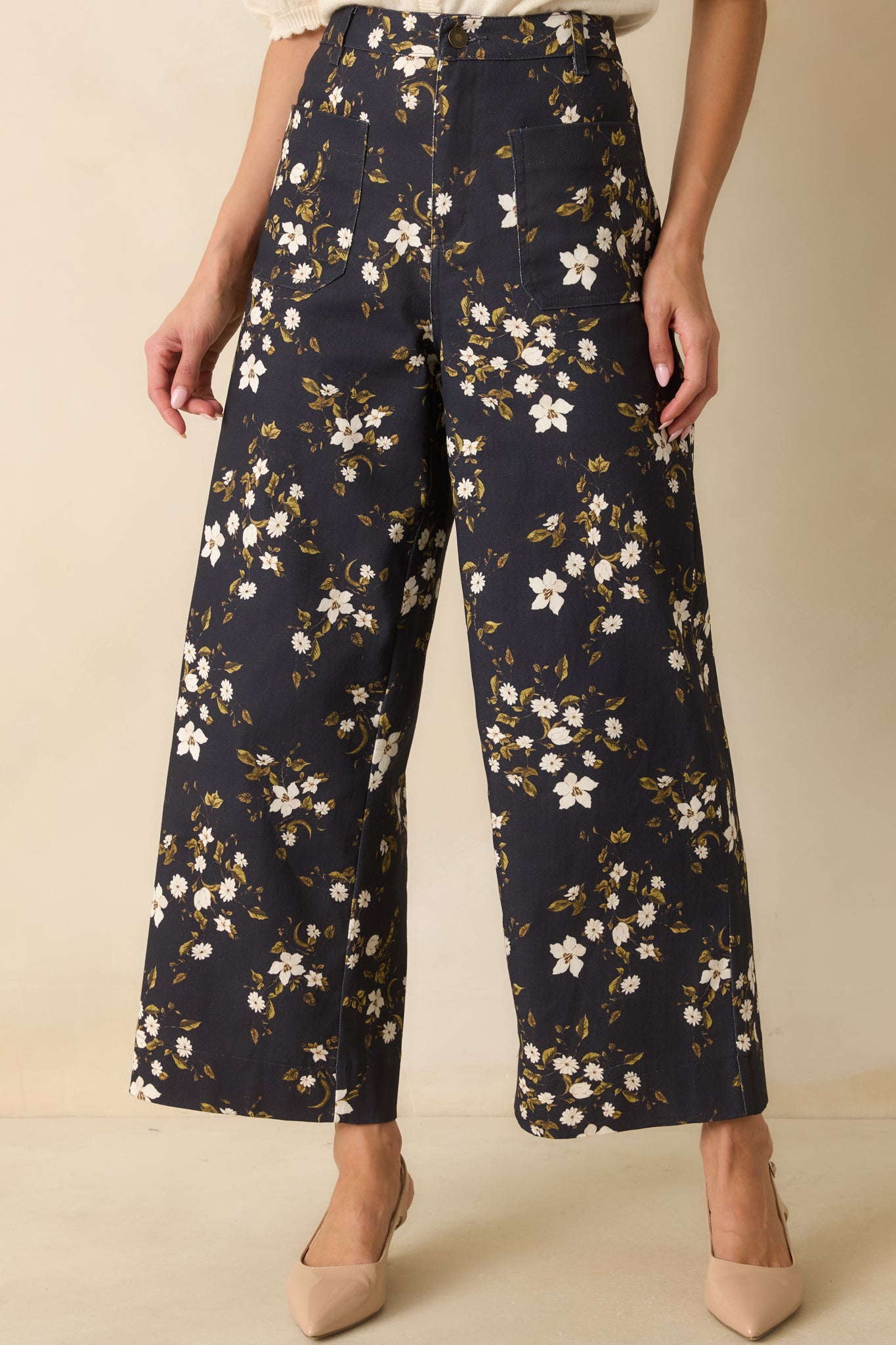 Up-close detail of the navy denim texture with ivory and olive floral print and stitching.