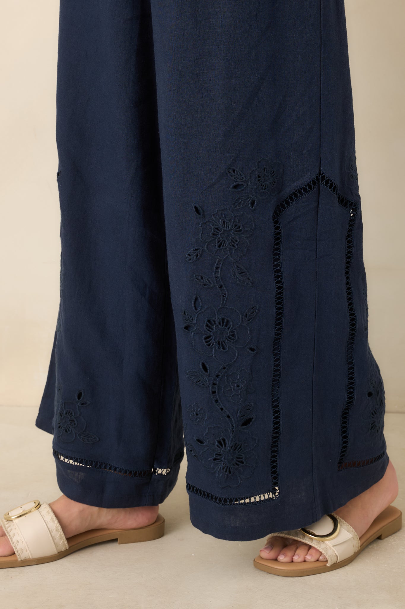 Close-up view of the floral embroidery, openwork trim, and textured linen blend fabric.