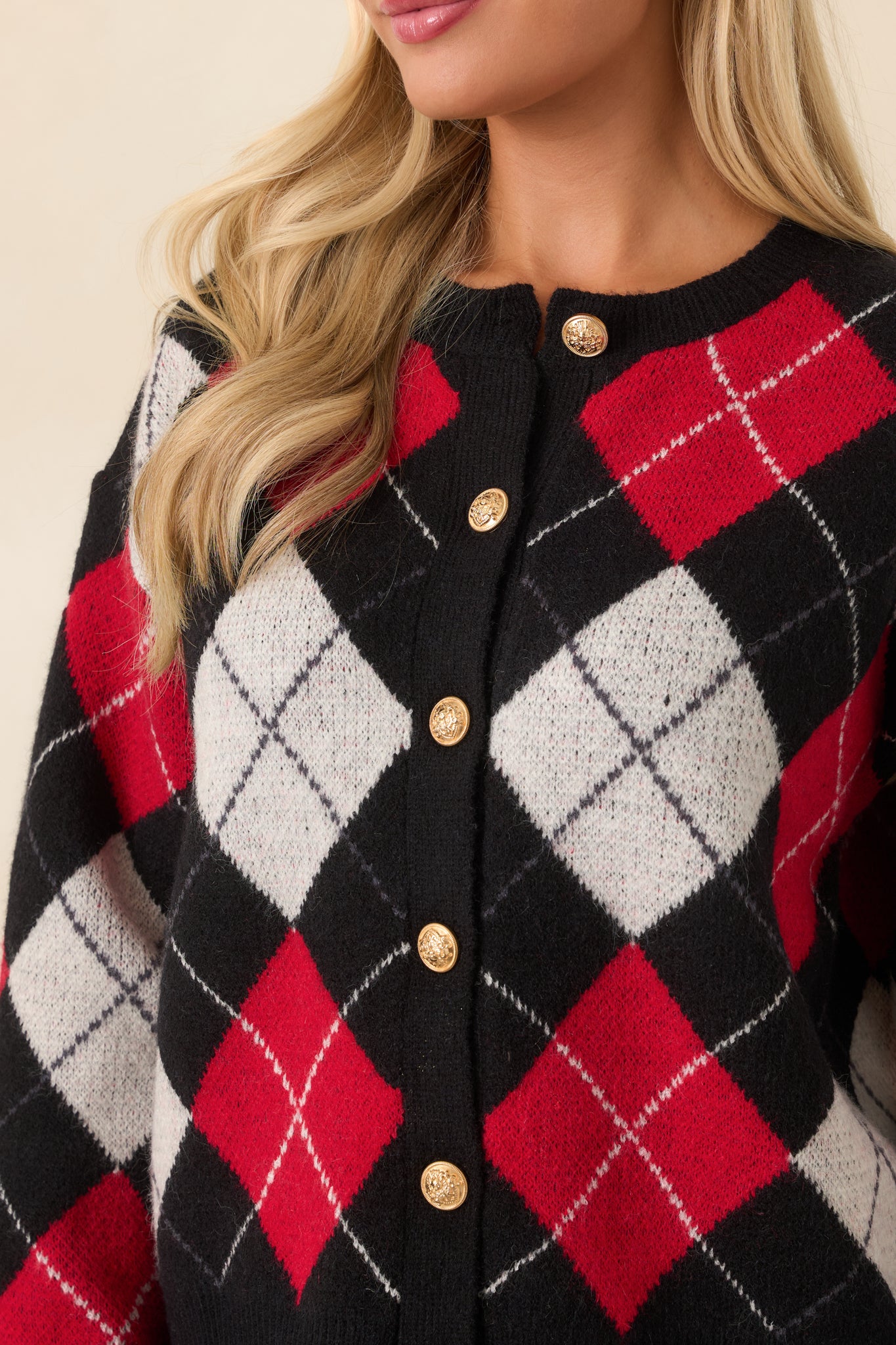 Close-up view of the ornate gold-tone buttons, argyle knit pattern, and ribbed trim details.
