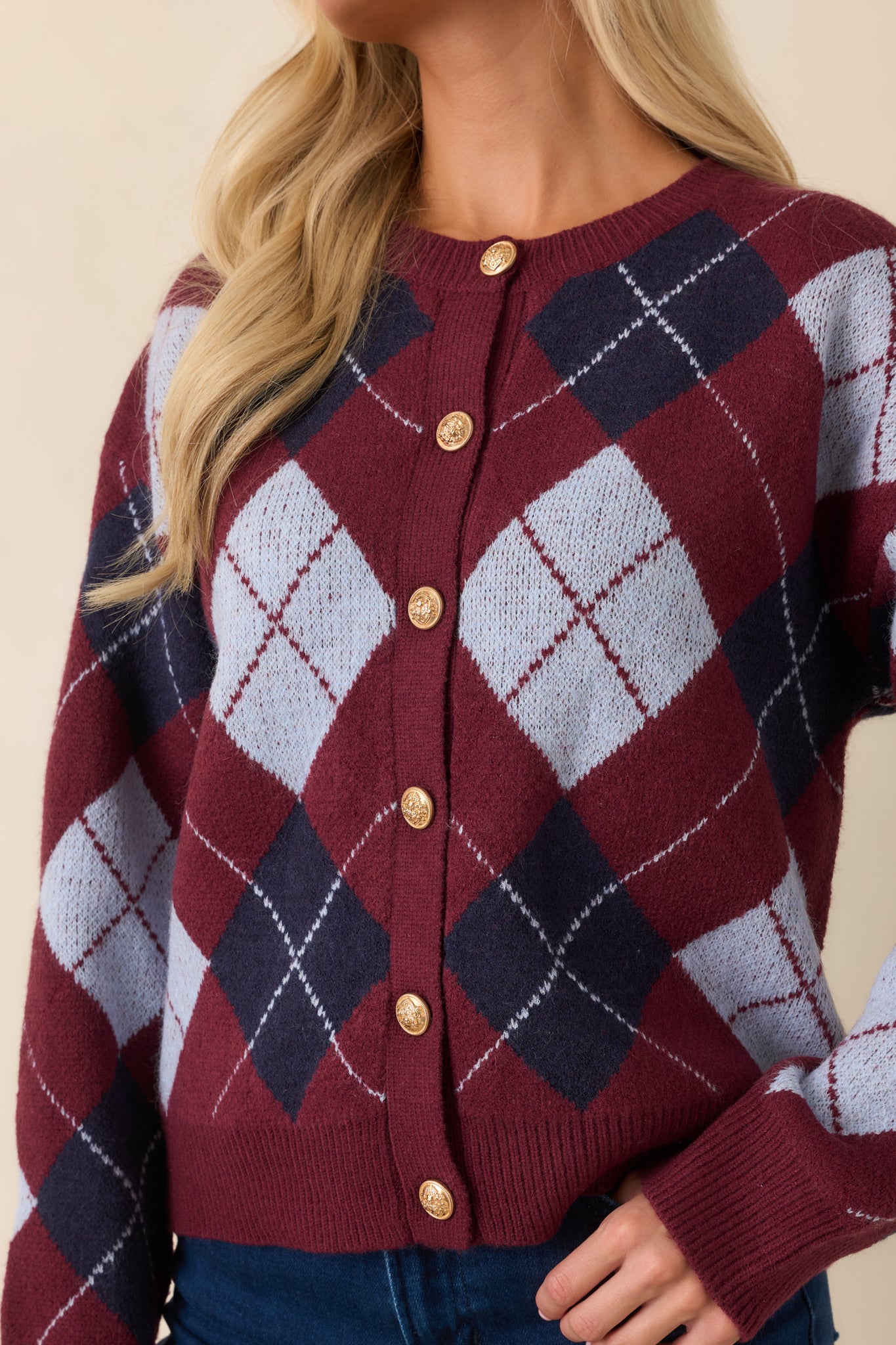 Close-up view of the ornate gold-tone buttons, diamond knit pattern, and ribbed trim details.
