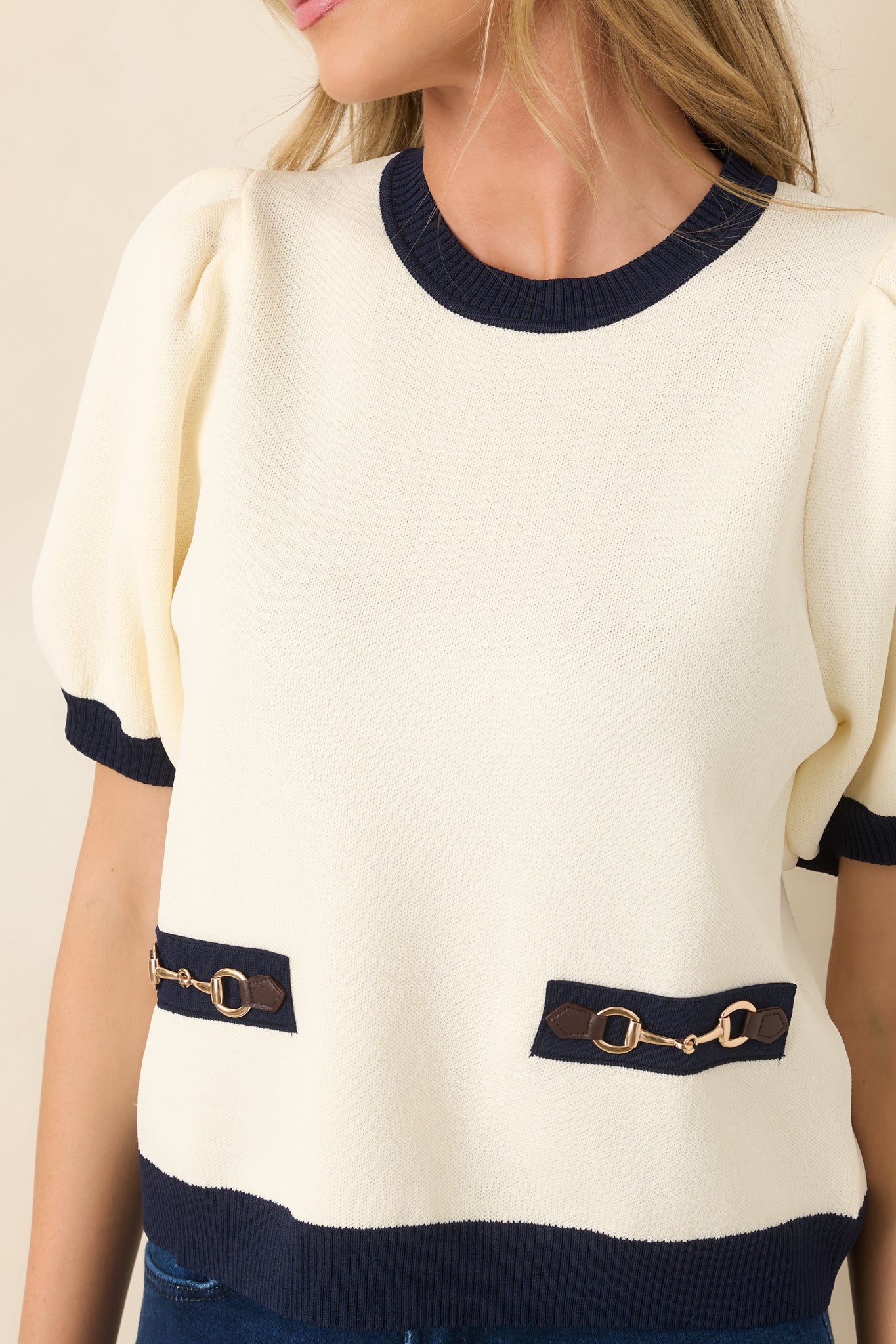 Close-up view of the gold-tone horsebit hardware, faux leather tabs, and navy ribbed trim.