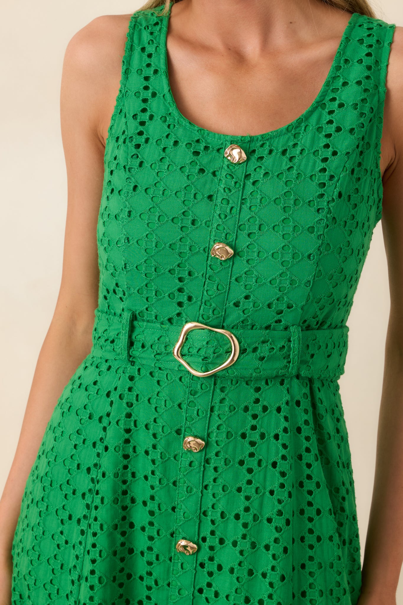 Close-up of intricate eyelet detailing over solid lining on cotton fabric.