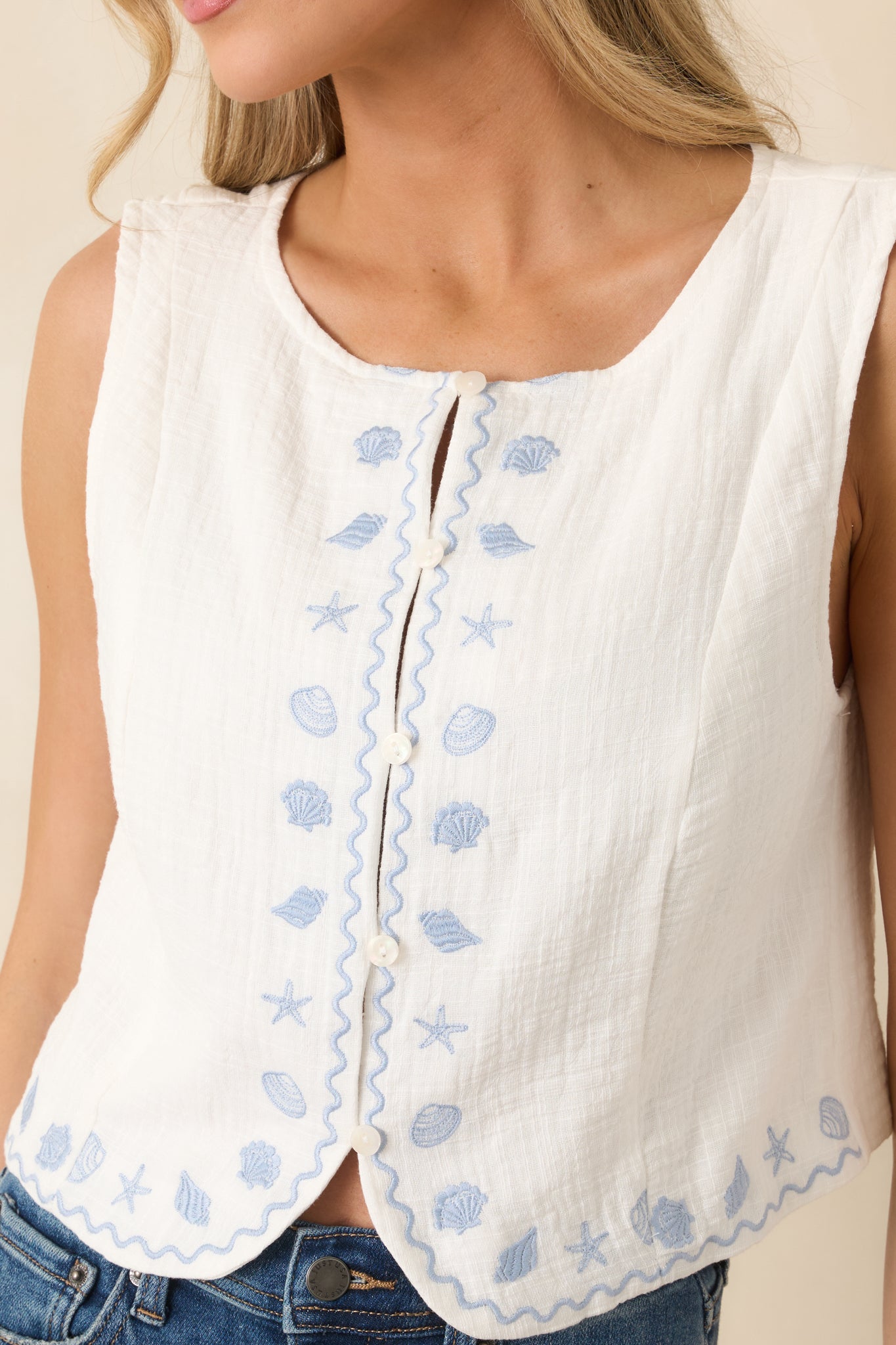 Close-up of ivory cotton fabric with front button detailing.
