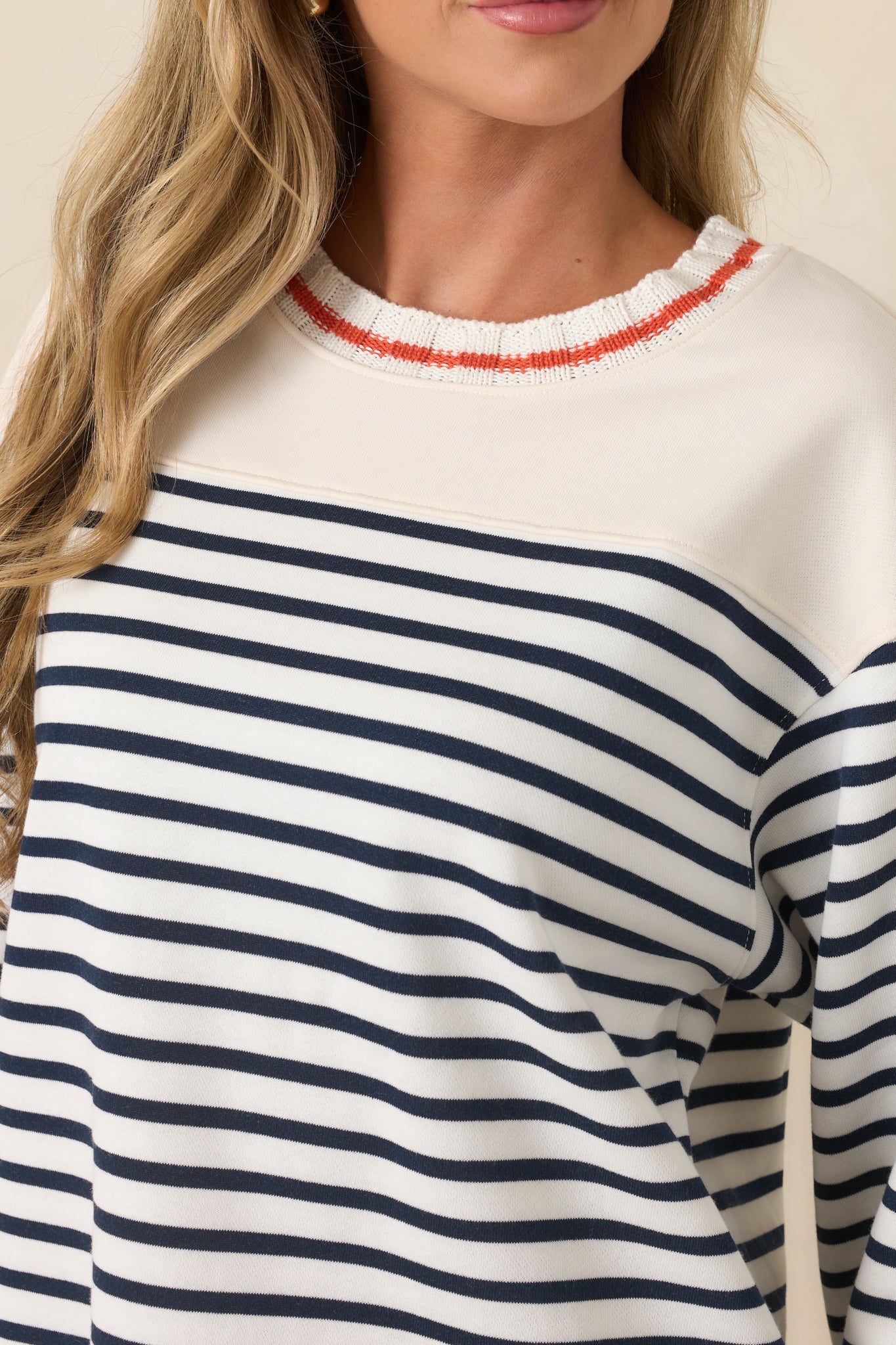 Close-up view of the navy and orange stripes, ribbed knit trim, and contrast shoulder panel details