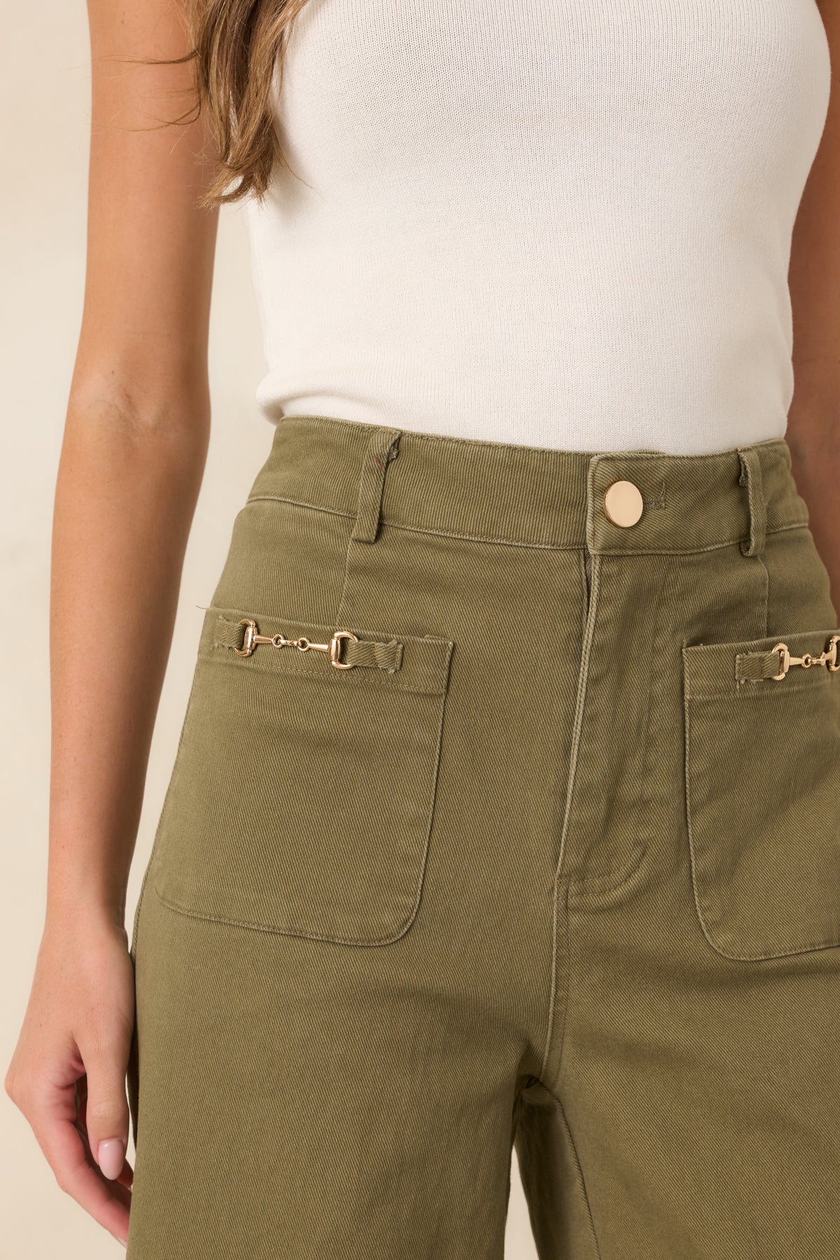 Close-up view of the oversized patch pockets, gold-tone horsebit details, and denim texture.