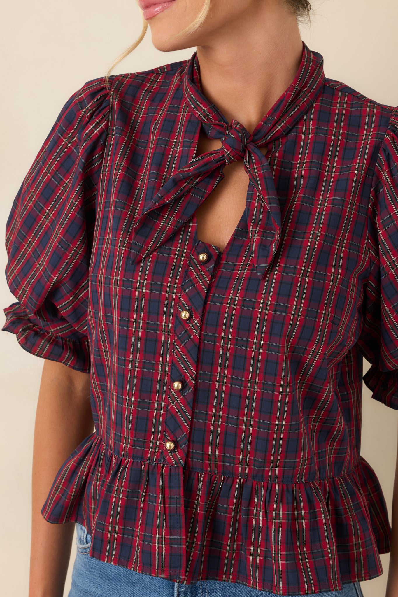 Close-up view of the self-tie neckline, gold-tone buttons, and textured ruffle details.