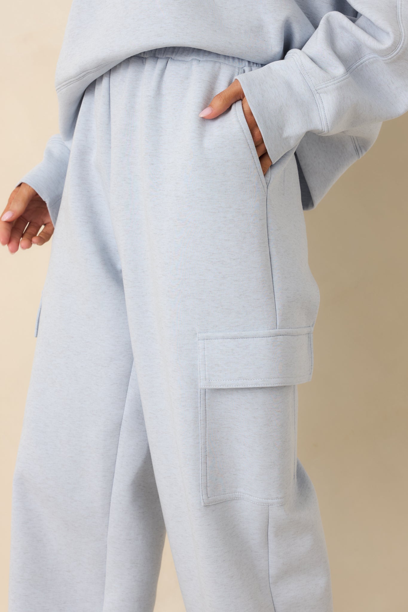 Close-up of side cargo pocket and knit texture on light blue jogger sweatpants.