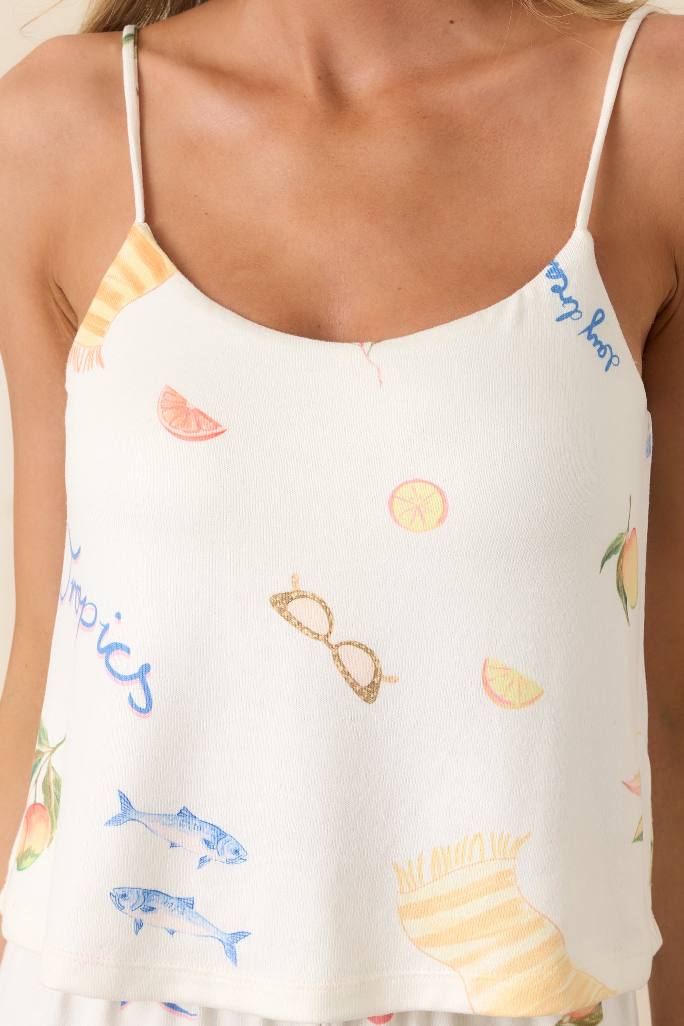 Close-up of silky fabric cami showcasing vintage-inspired tropical print with citrus and “Club Tropics” text