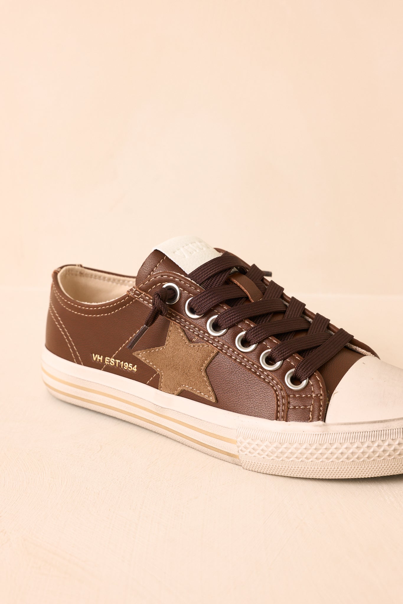 Close-up view of the suede star, contrast stitching, and layered rubber sole details.