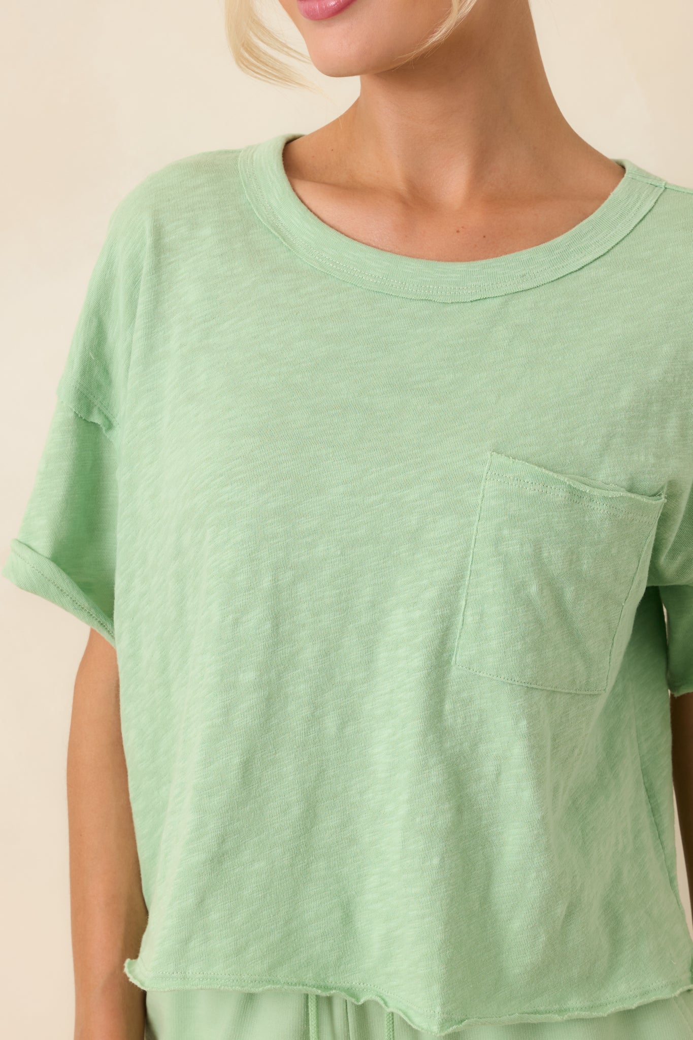 Close-up of tee showing front chest pocket detail and soft fabric texture.
