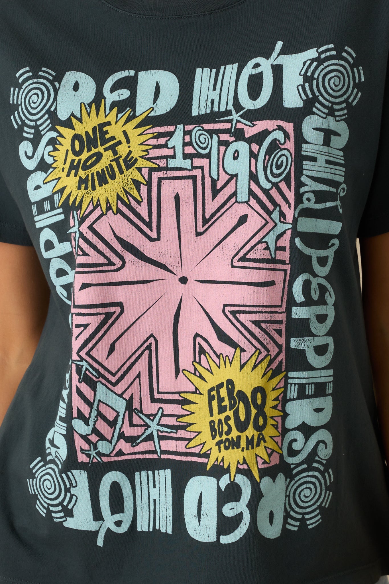 A close-up of the bold front design featuring the pink star motif, yellow comic-style accents, and tour lettering.