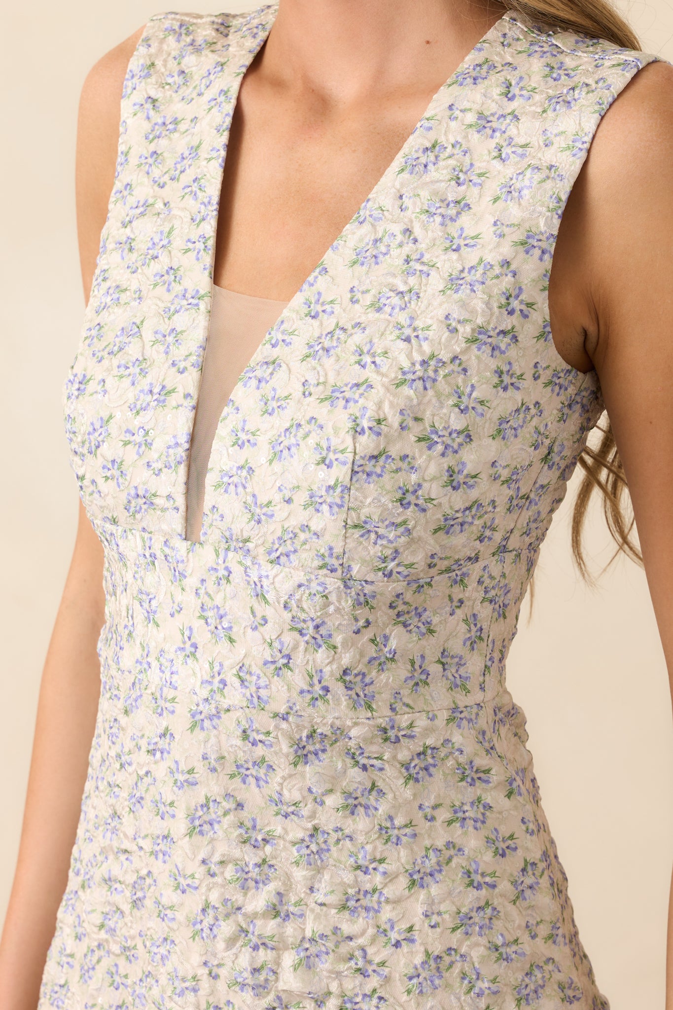 Close-up of the deep v-neckline with mesh panel and floral jacquard fabric, showing intricate texture and stitch detail.