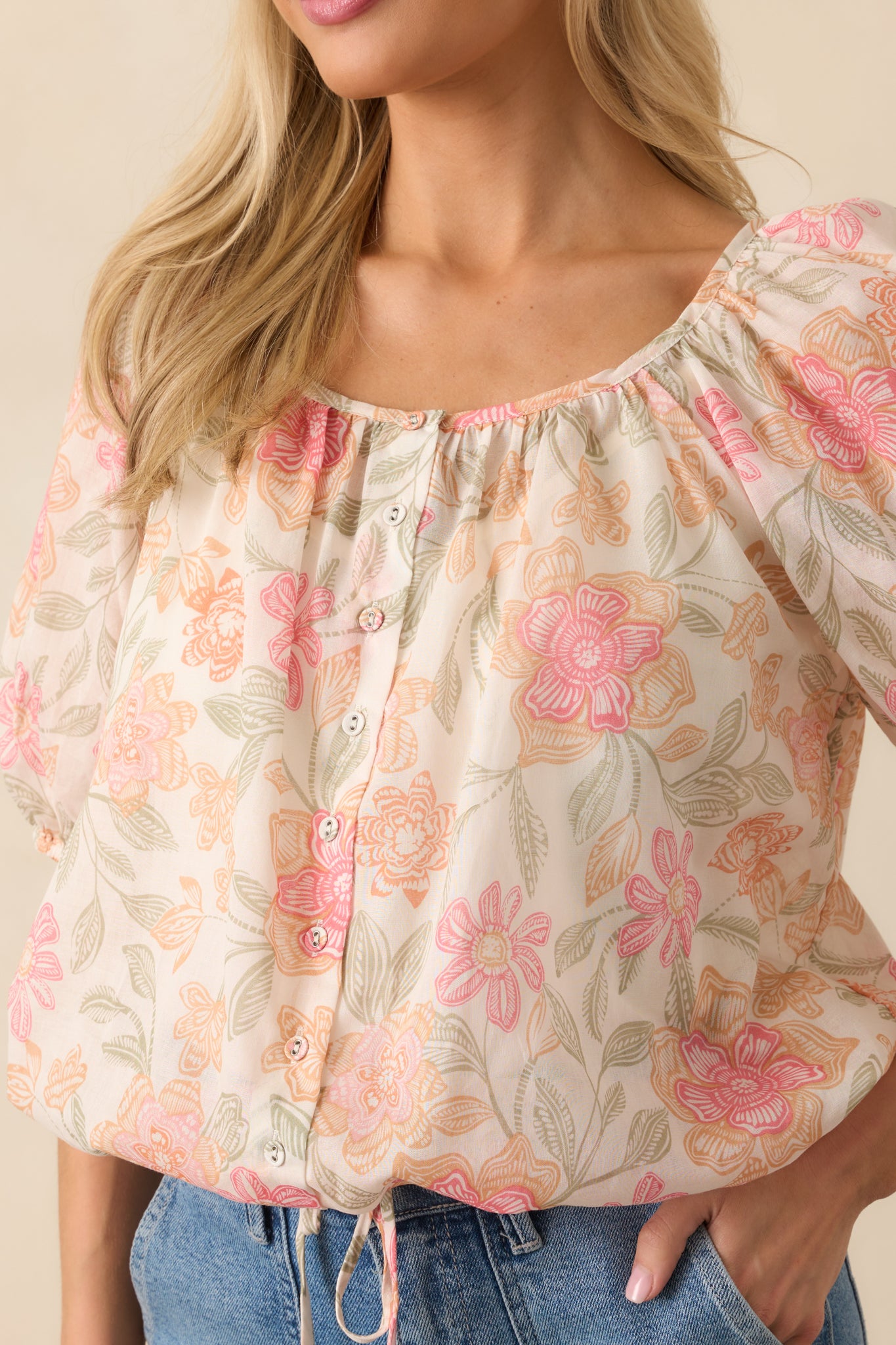 Close-up of the floral print on the sheer overlay with a focus on the stitching and button detailing, showing the contrast between the translucent fabric and solid ivory lining beneath.