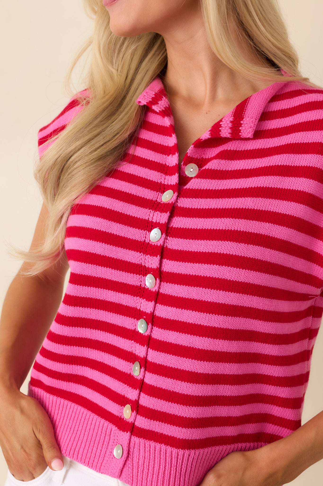 Close-up of the vibrant red and pink stripes, button-front closure, and collared neckline details.
