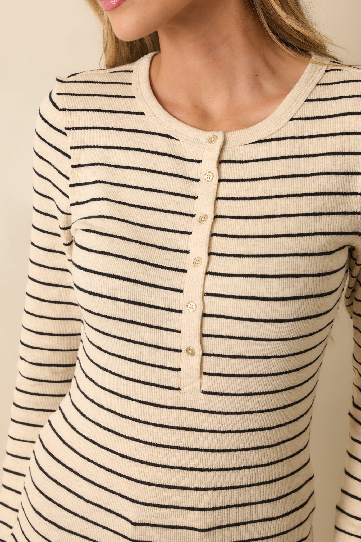 Close-up detail shot of the ribbed fabric, stripe pattern, and button placket.