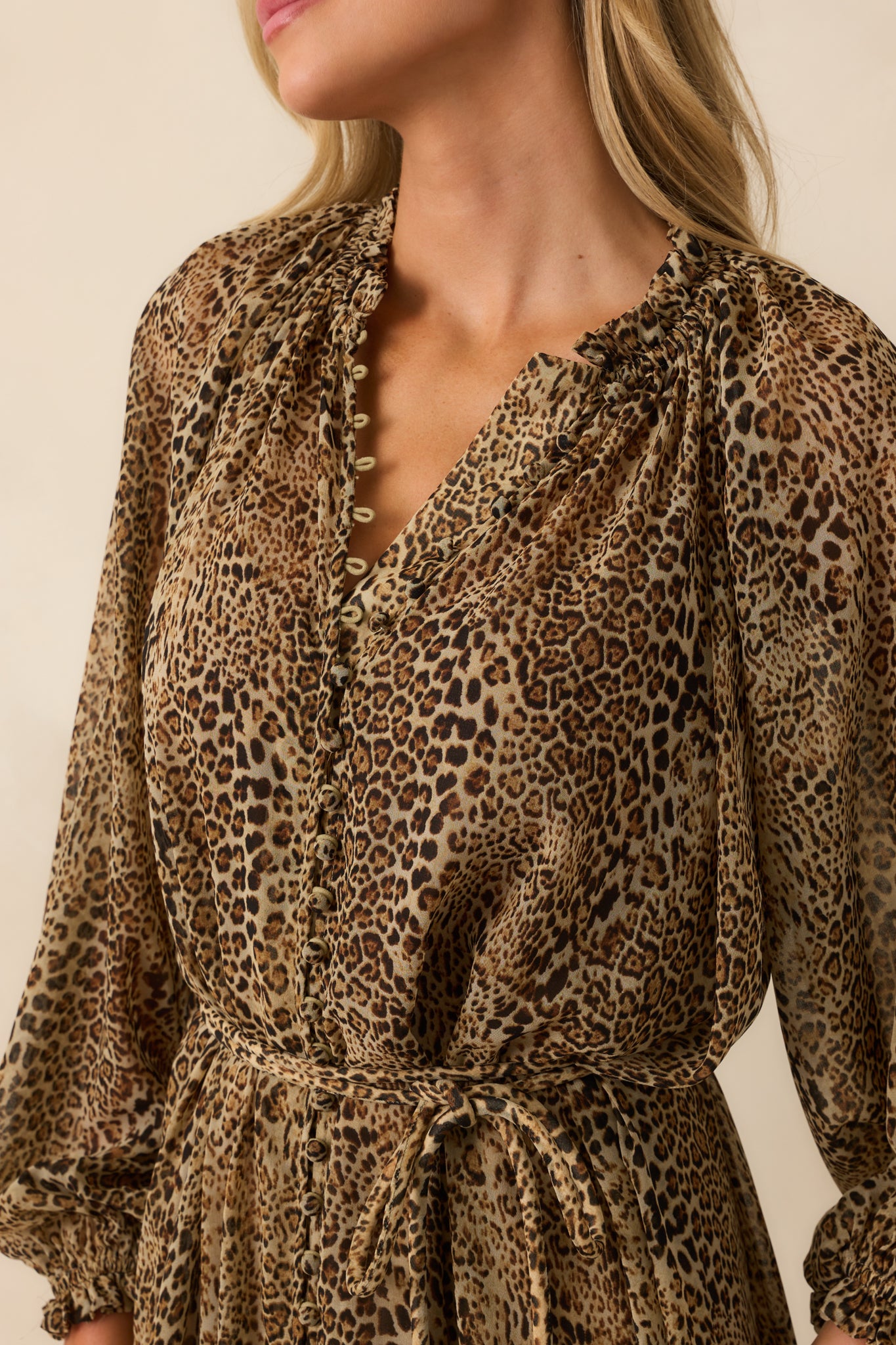 Close-up of the ruffle trim, button-front closure, and leopard print chiffon overlay.