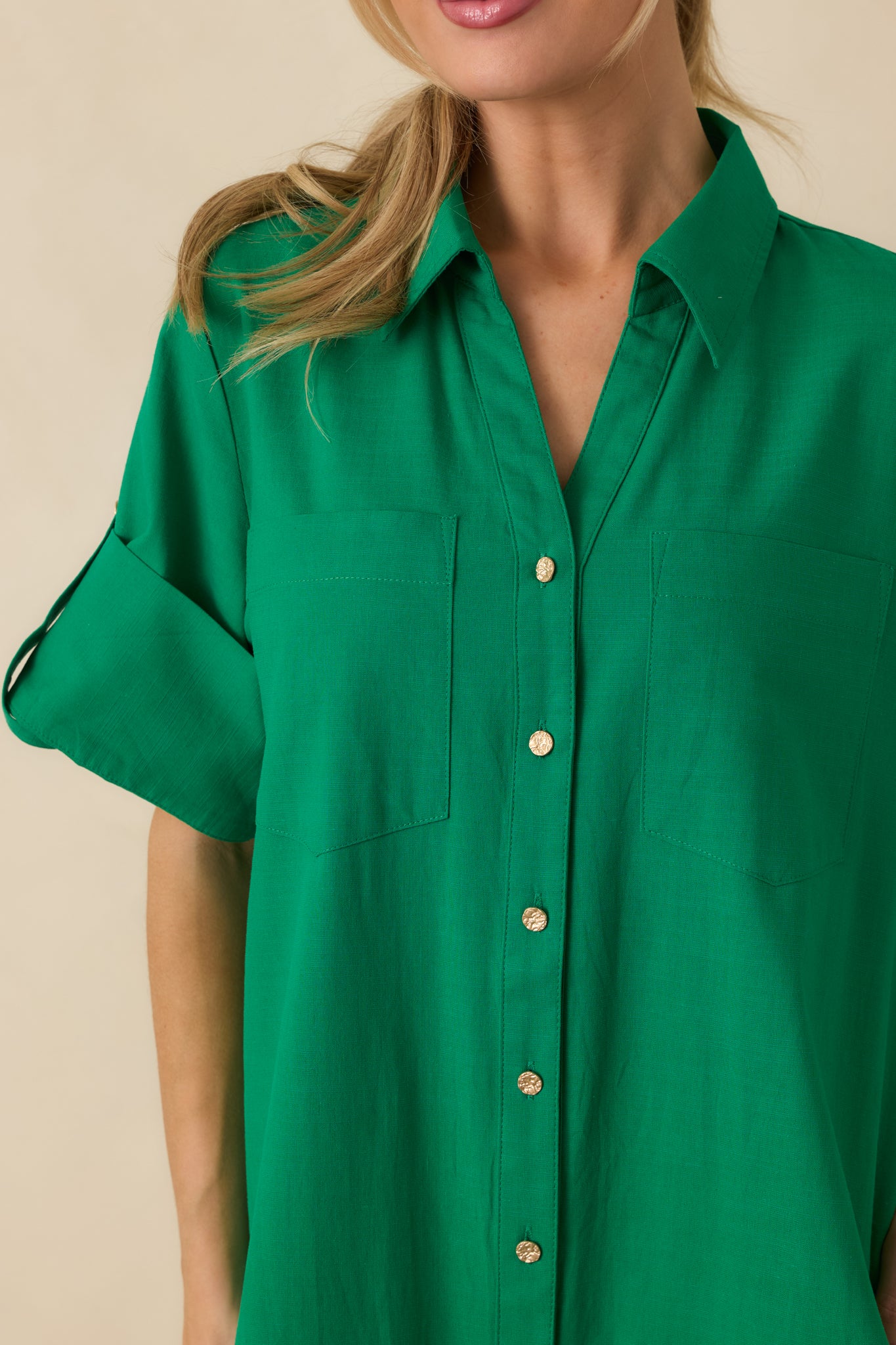 Close-up of green shirt dress showing gold-tone buttons, collared neckline, and soft cotton weave.