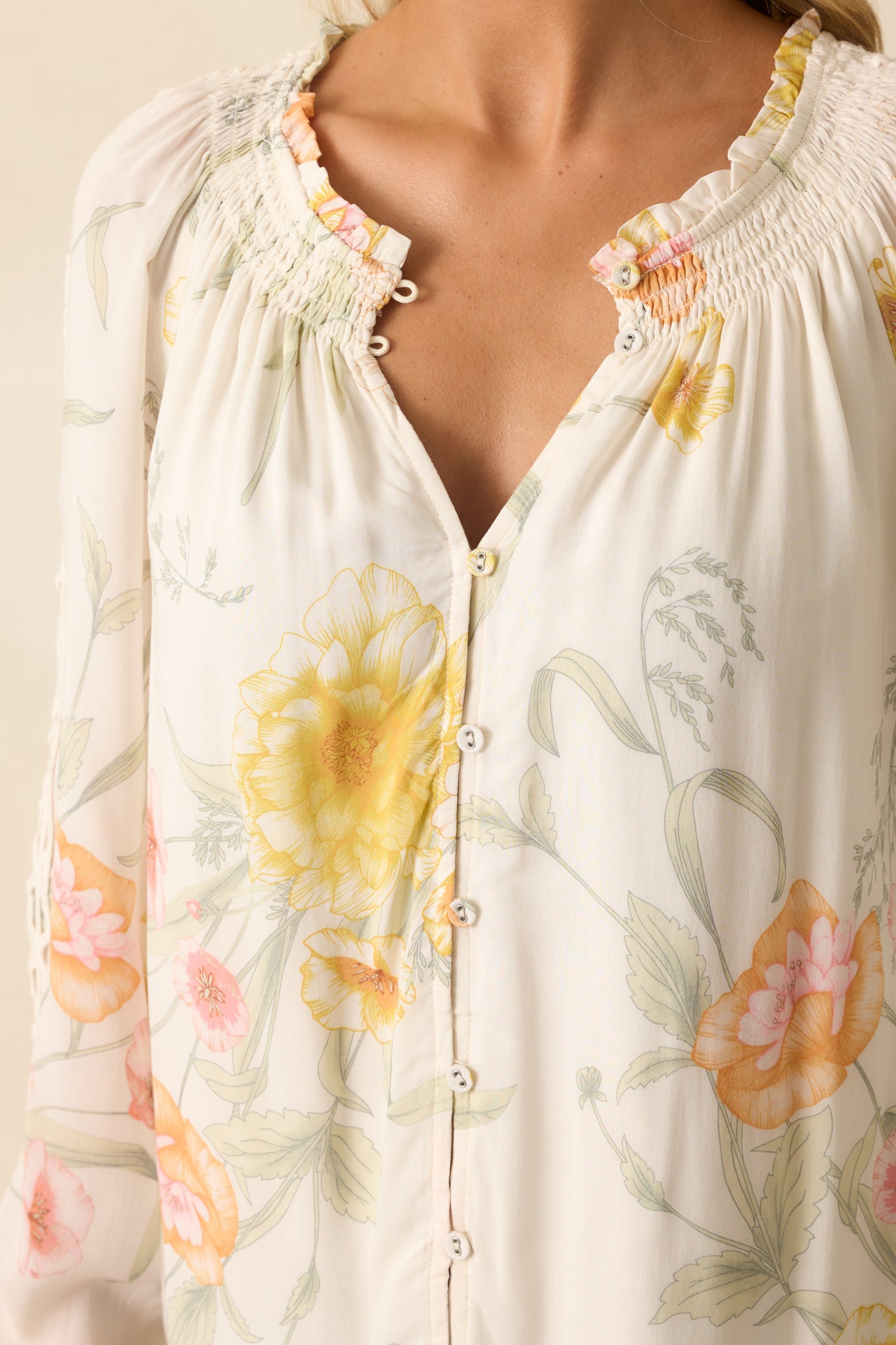 A detailed close-up of the smocked ruffle neckline, floral print, and embroidered trim.