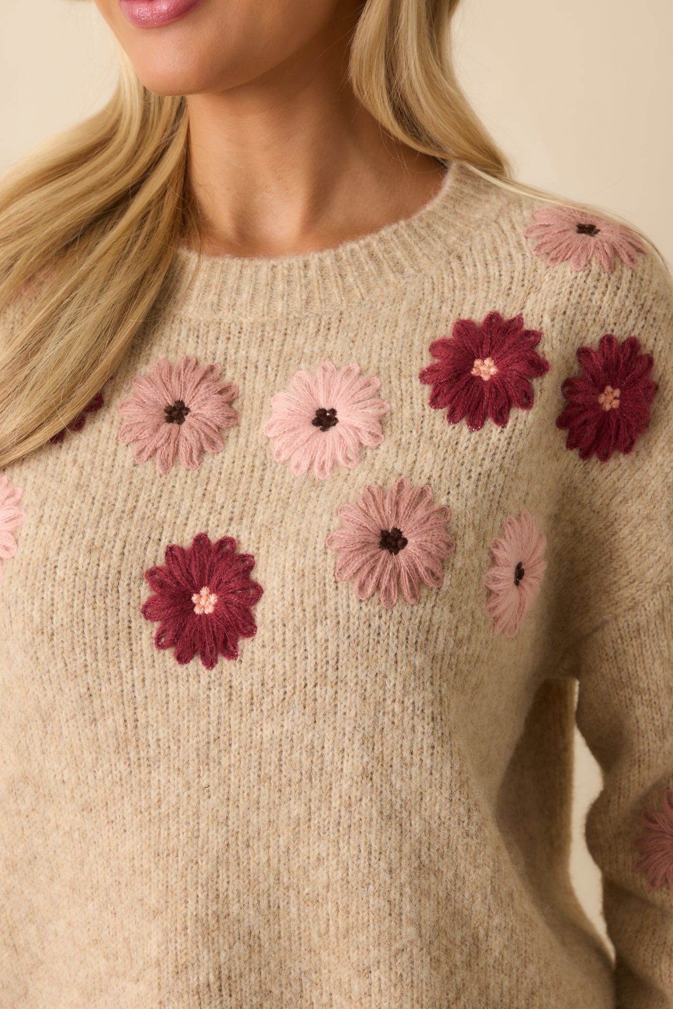 Close-up of the textured floral embroidery, capturing the warm blush, rose, and wine tones and knit craftsmanship.