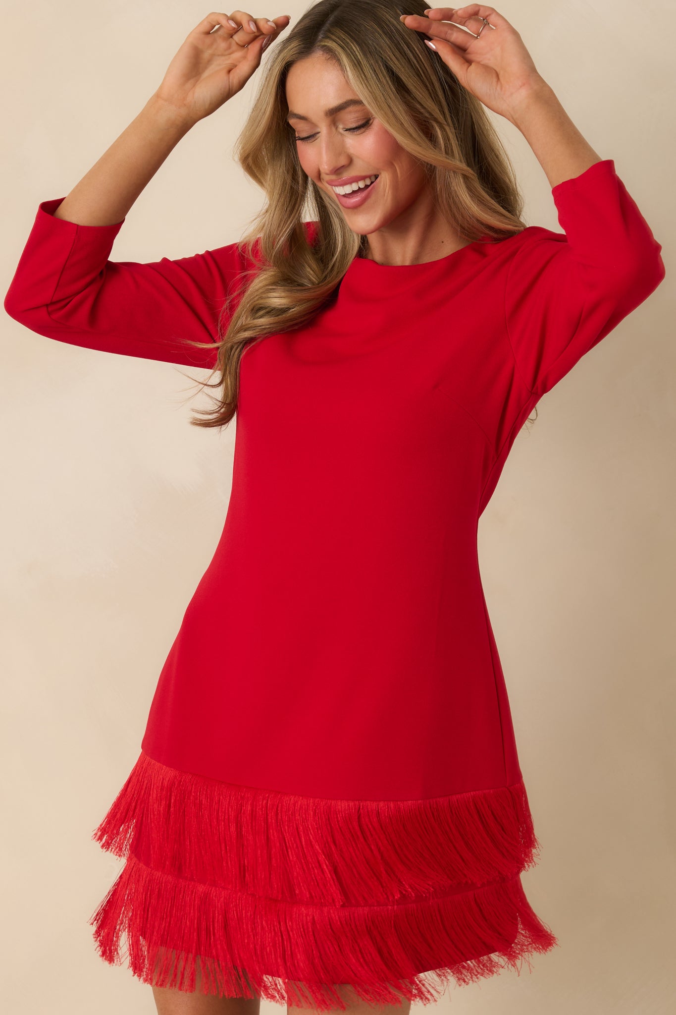 Zoomed-in look at the tiered fringe hem of the red mini dress, emphasizing texture and movement.