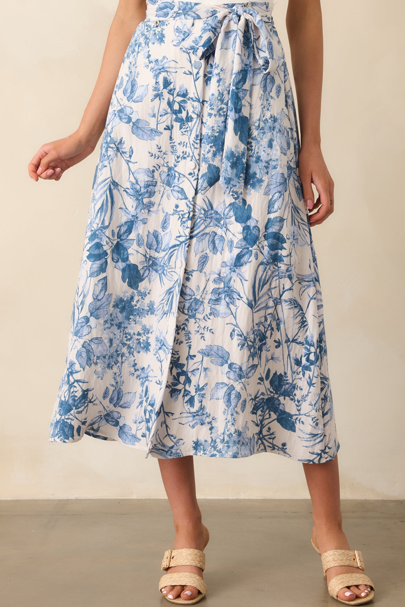 Cropped photo focusing on the waistband, showing the back elastic waist and belt loops of the blue floral skirt.