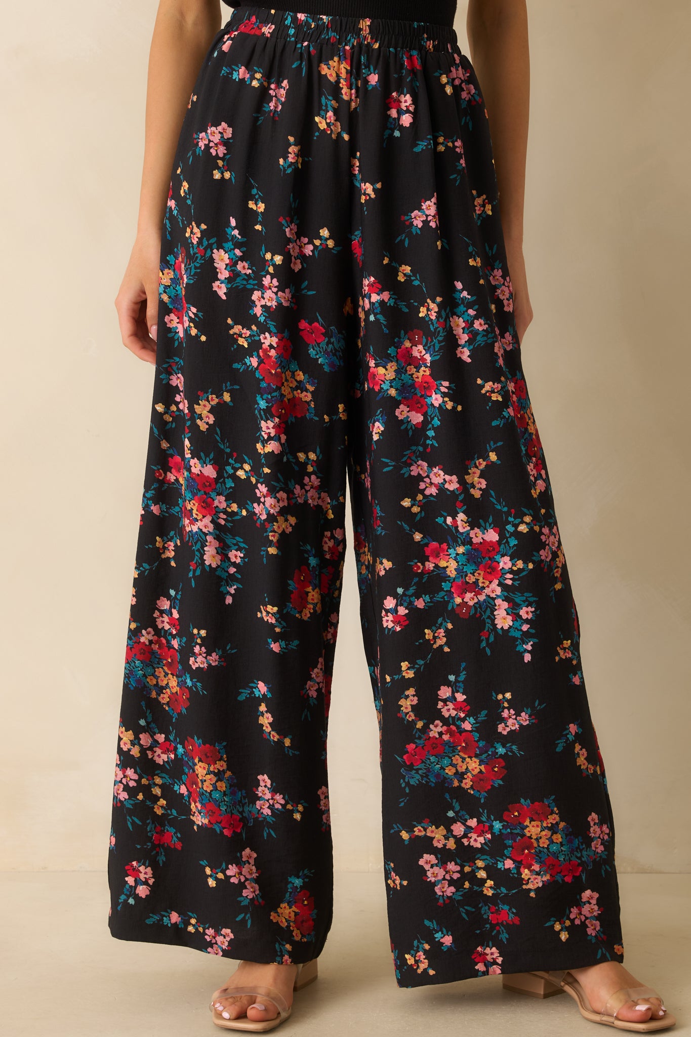 Close view of the elastic waistband and floral print detail at the top of the pants.