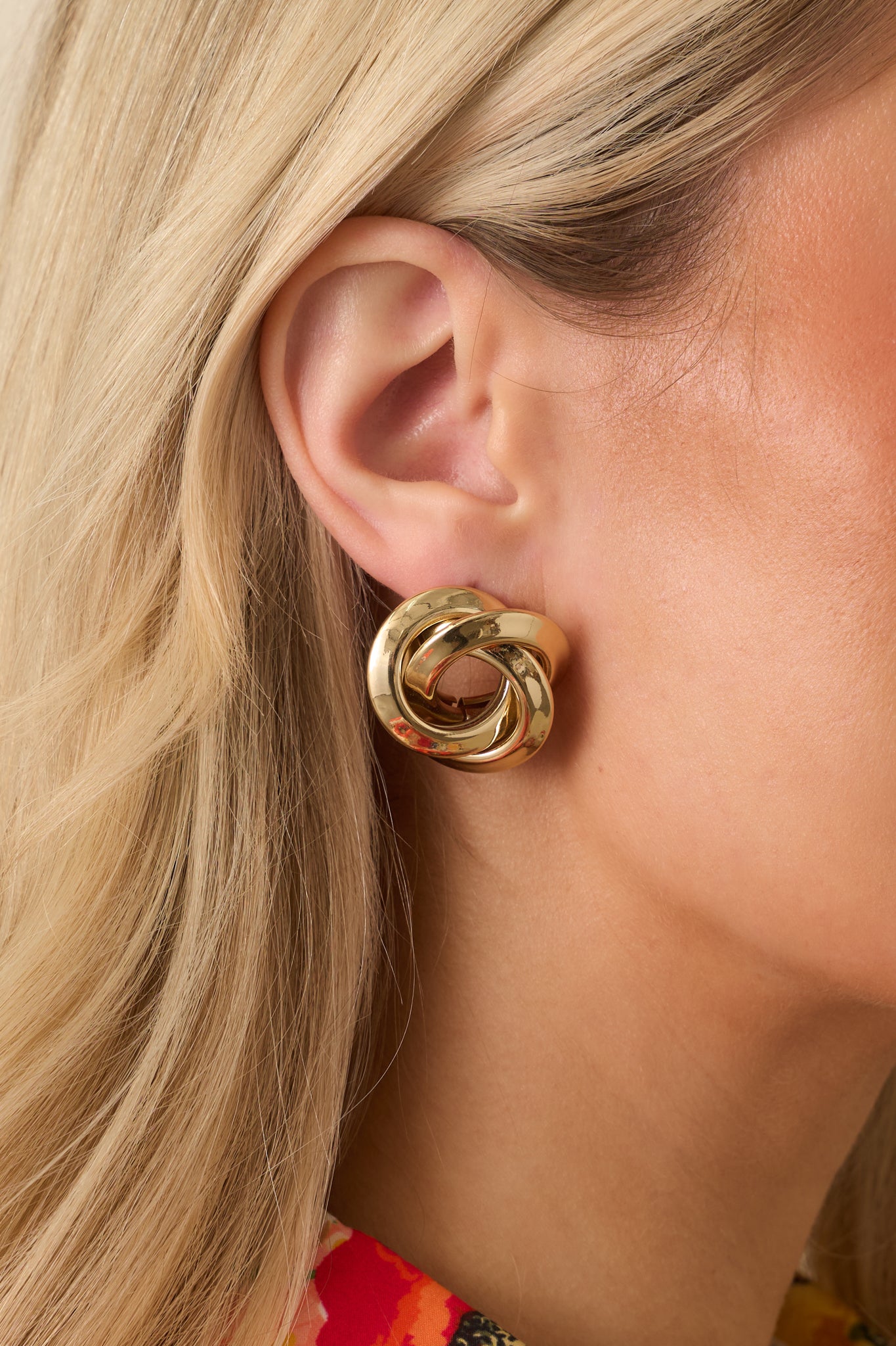 Cropped view of gold twisted spiral earrings showing hollow center and sleek polished surface.