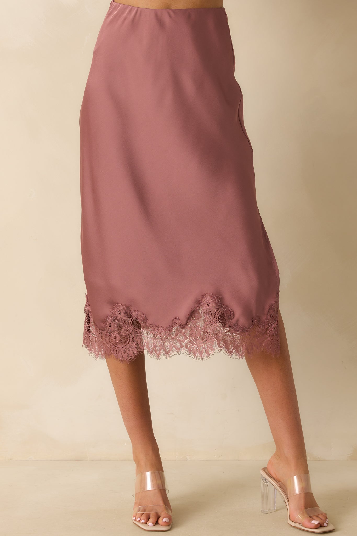 Close view of the high-rise elastic waistband and smooth satin fabric of the skirt.