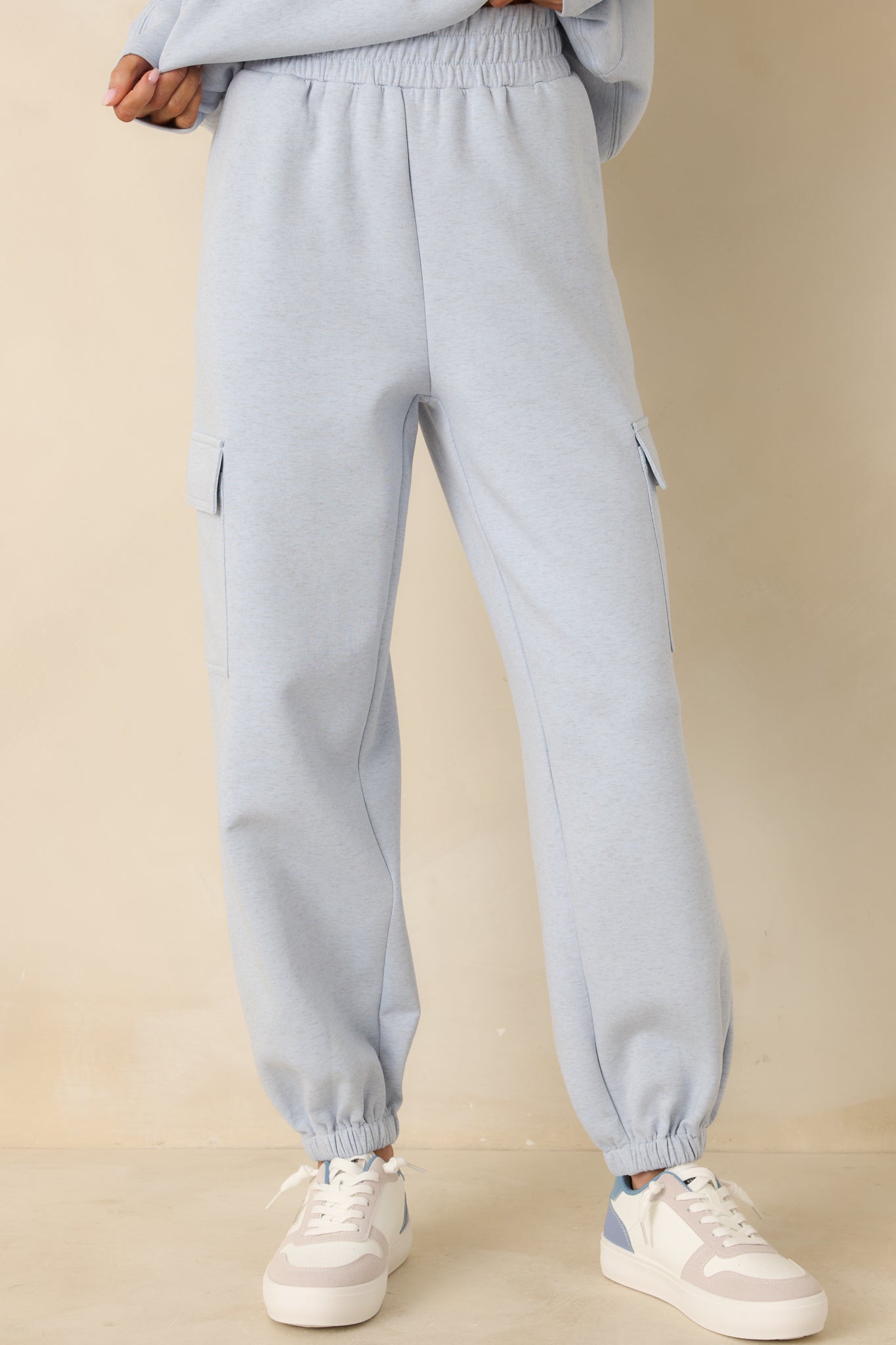 Close view of elastic waistband and soft knit texture on light blue joggers.