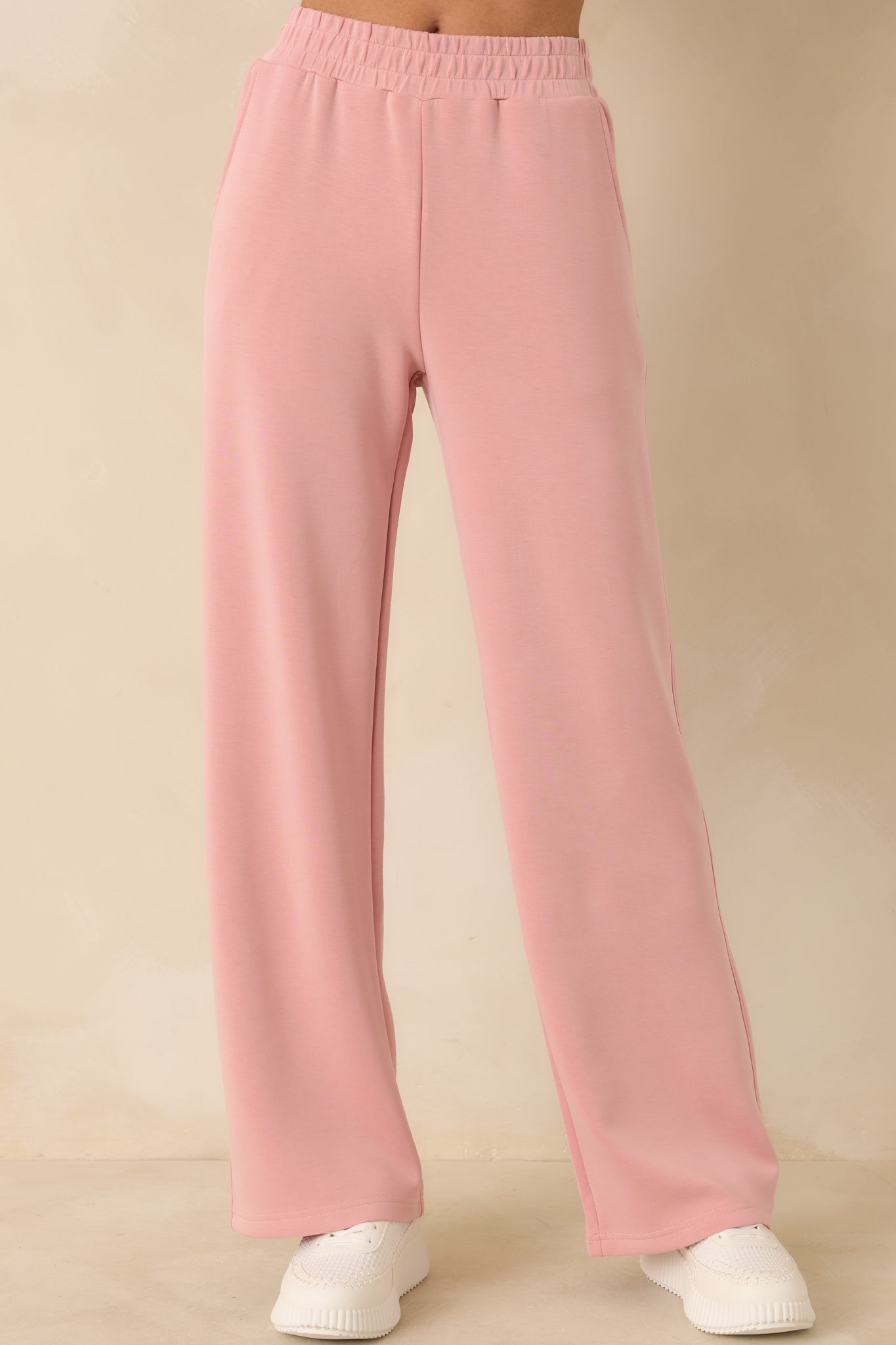 Close view of elastic waistband and knit texture on powder pink pants.