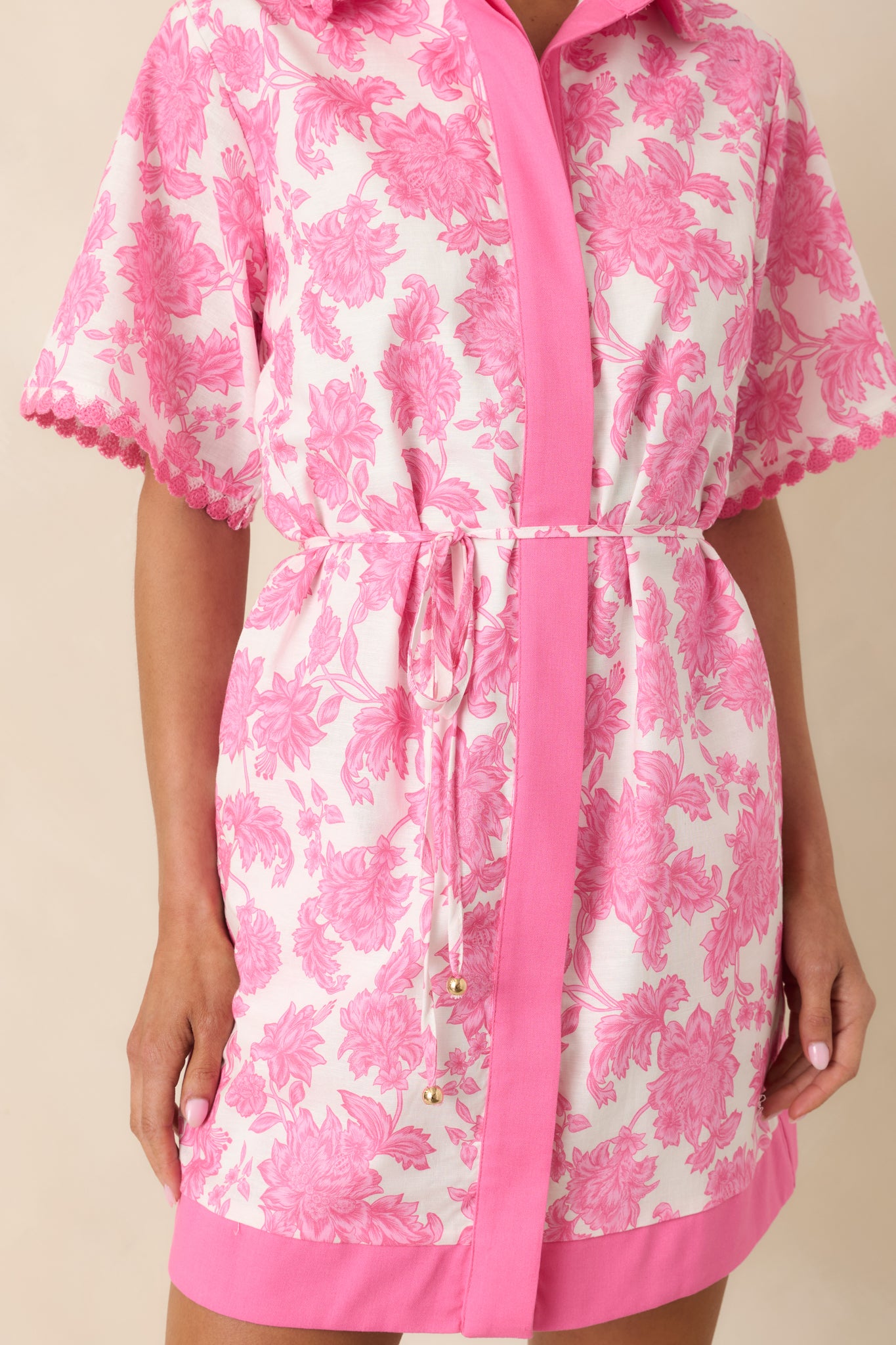 Close view of floral print with contrast trim and button-front detail on structured fabric.