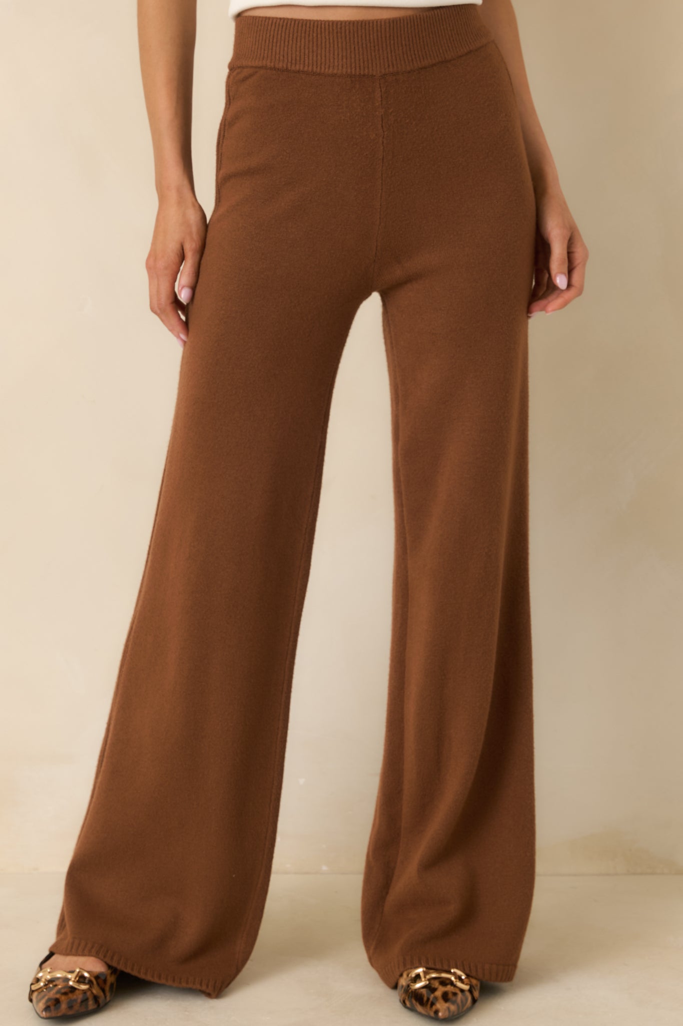 Close view of ribbed side detailing and soft knit texture on brown pants.
