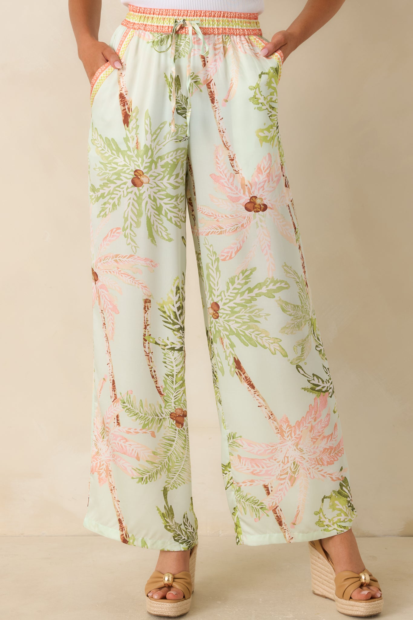 Close view of the elastic waistband with adjustable drawstring tie on the mint tropical print pants.