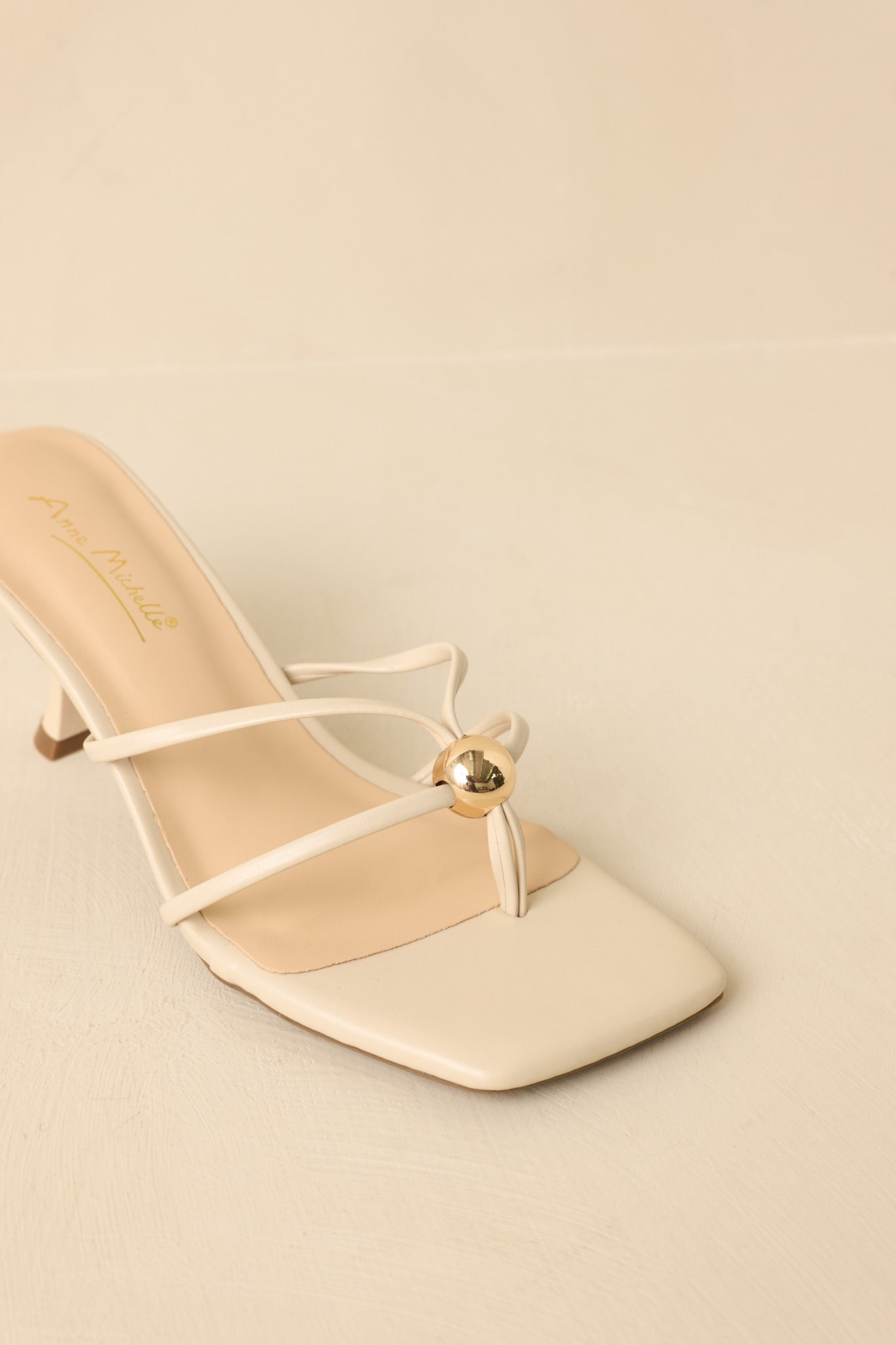 Close view of the gold bead accent and slim straps on the cushioned sandal footbed.