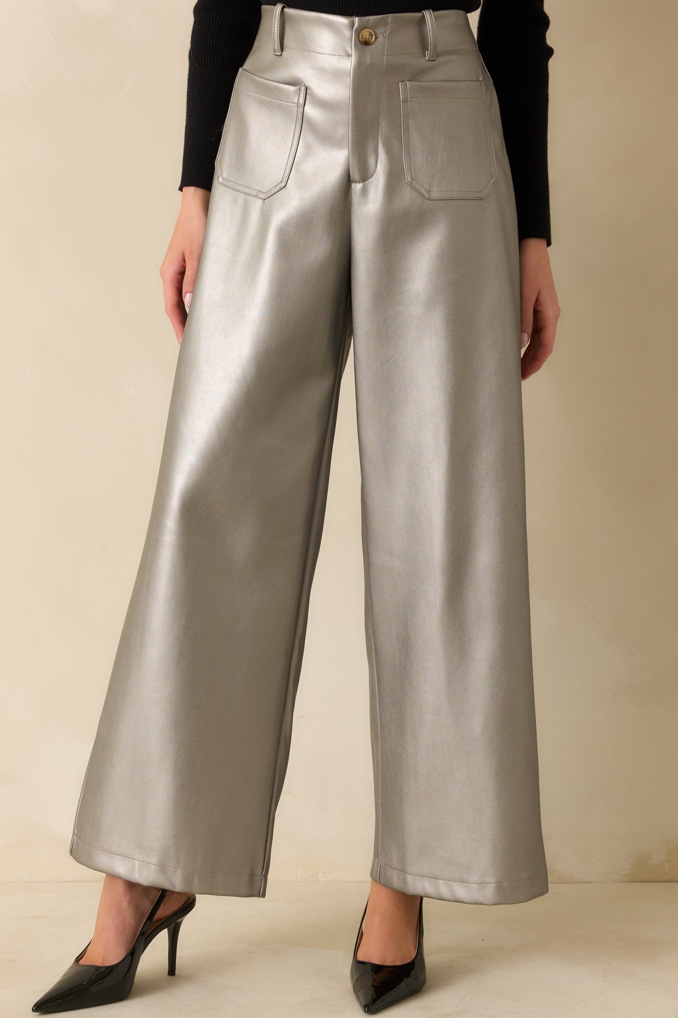 Close view of the high-rise waistband and front patch pocket details with a smooth metallic sheen.