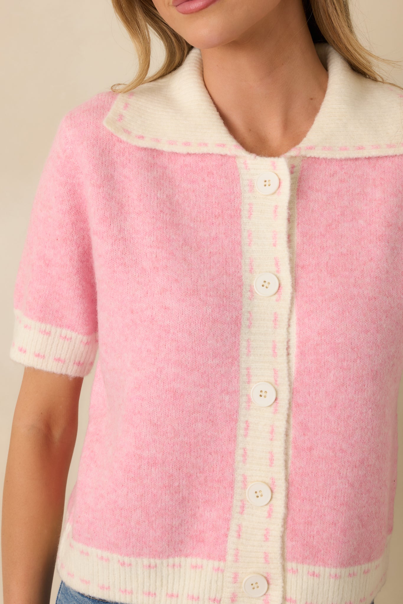 Close view of the soft, lightweight knit blend showcasing the ivory contrast trim and structured collar edge.