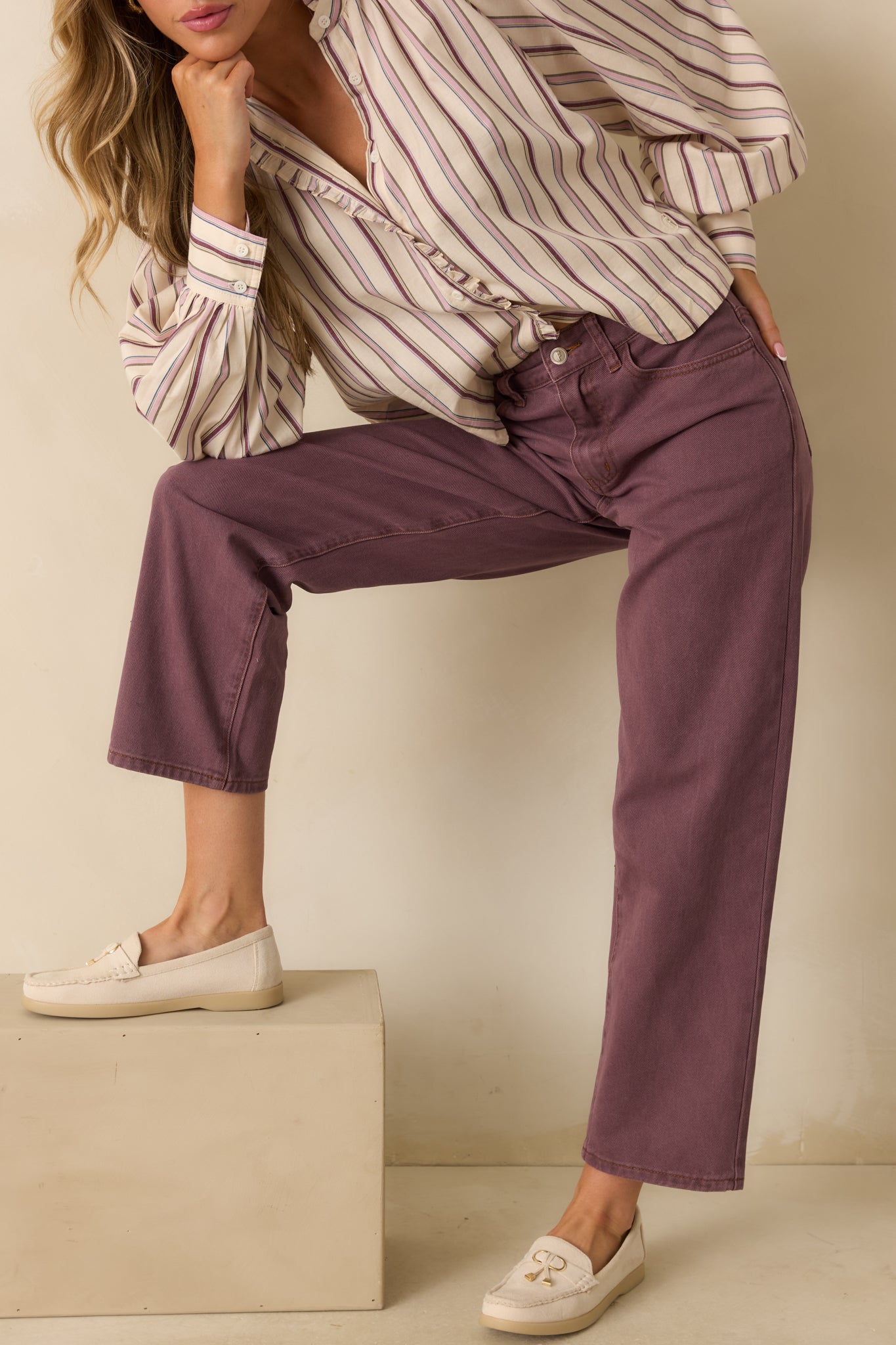 Close view of the waistband and zip fly of the violet jeans, highlighting the front pocket detailing.