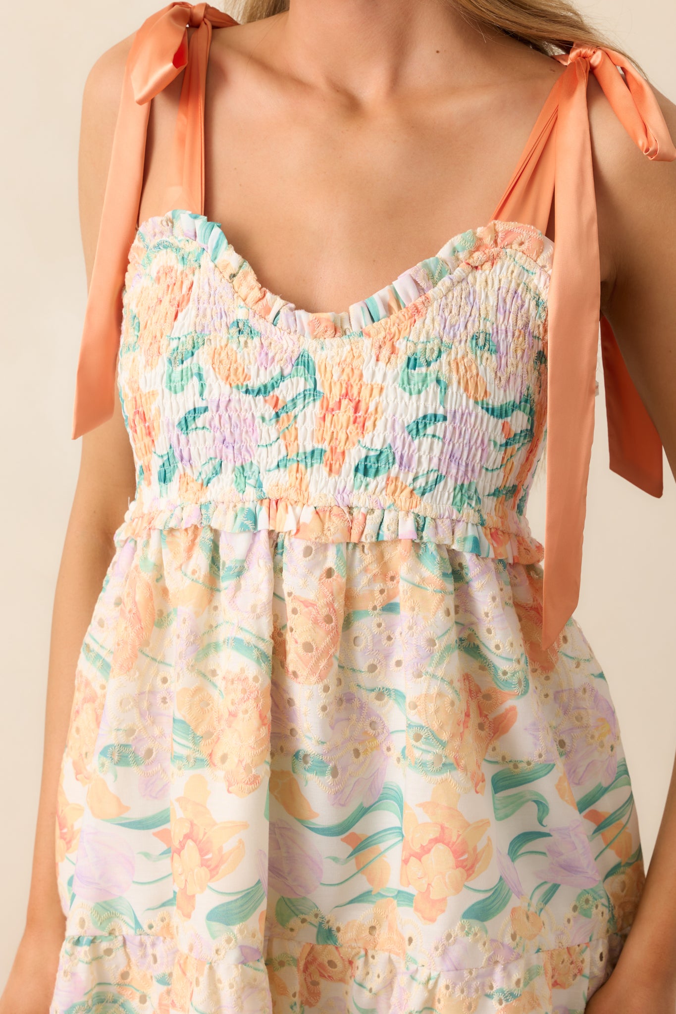 A closer look at the embroidered eyelet detailing and multicolor floral print, showcasing the intricate craftsmanship of this beautiful dress.