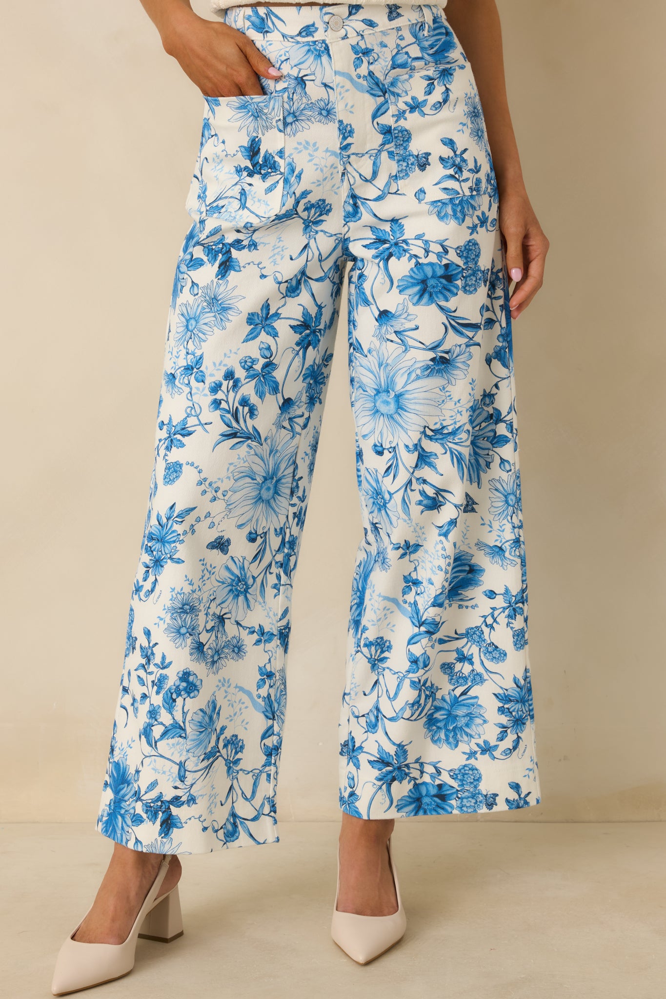 Closer view of the high-rise waistband and front button and zipper closure with blue floral print.