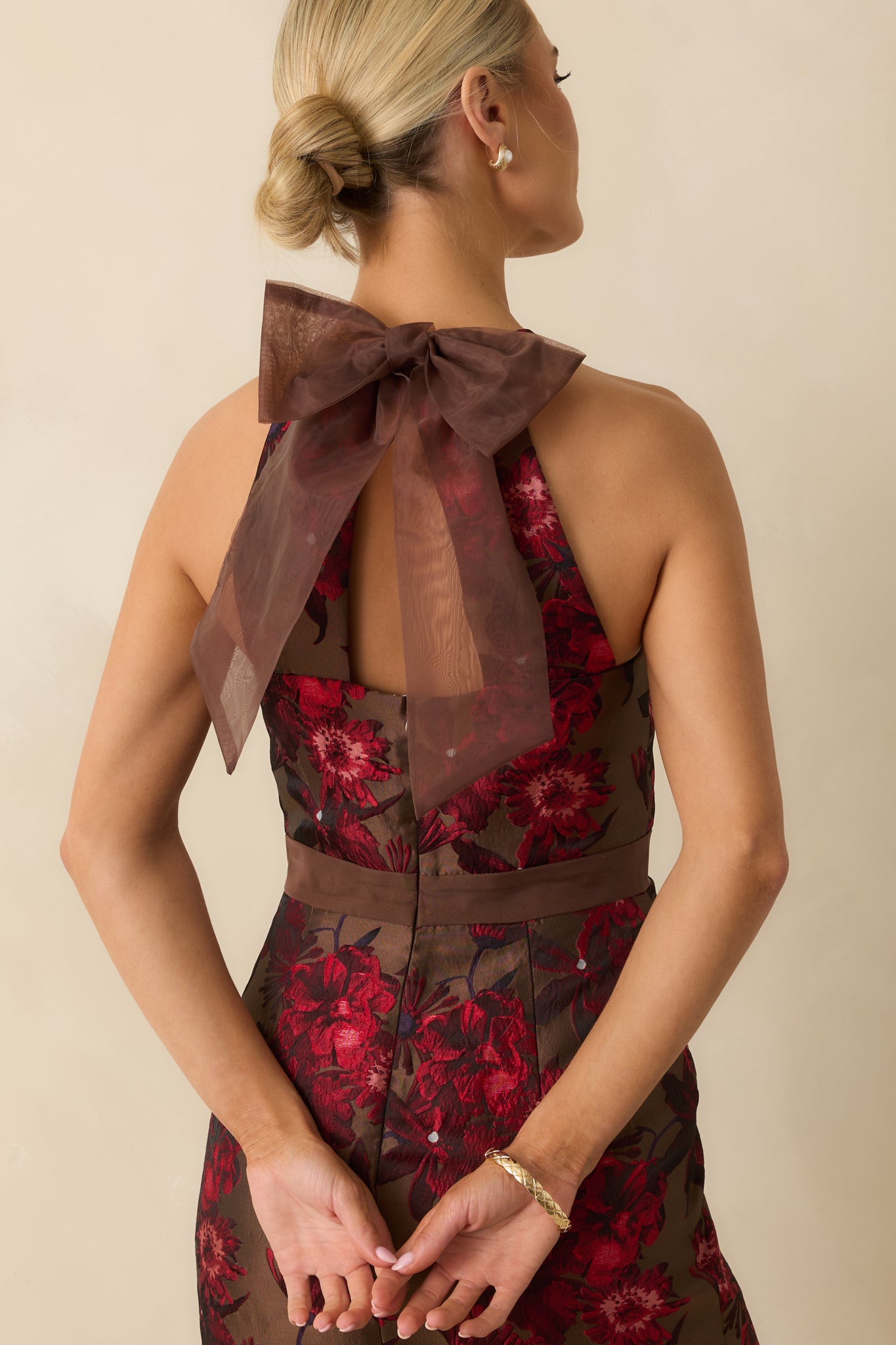 Close-up of the rear of the mocha brown floral jacquard midi dress showing the adjustable back bow tie, concealed zipper, and textured woven fabric.