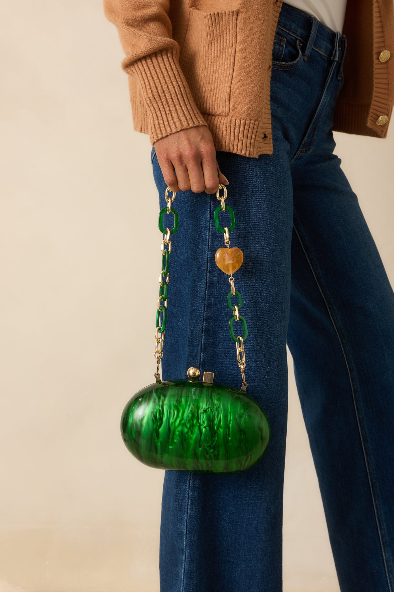 A cropped side angle showing the glossy finish and optional gold chain crossbody strap.