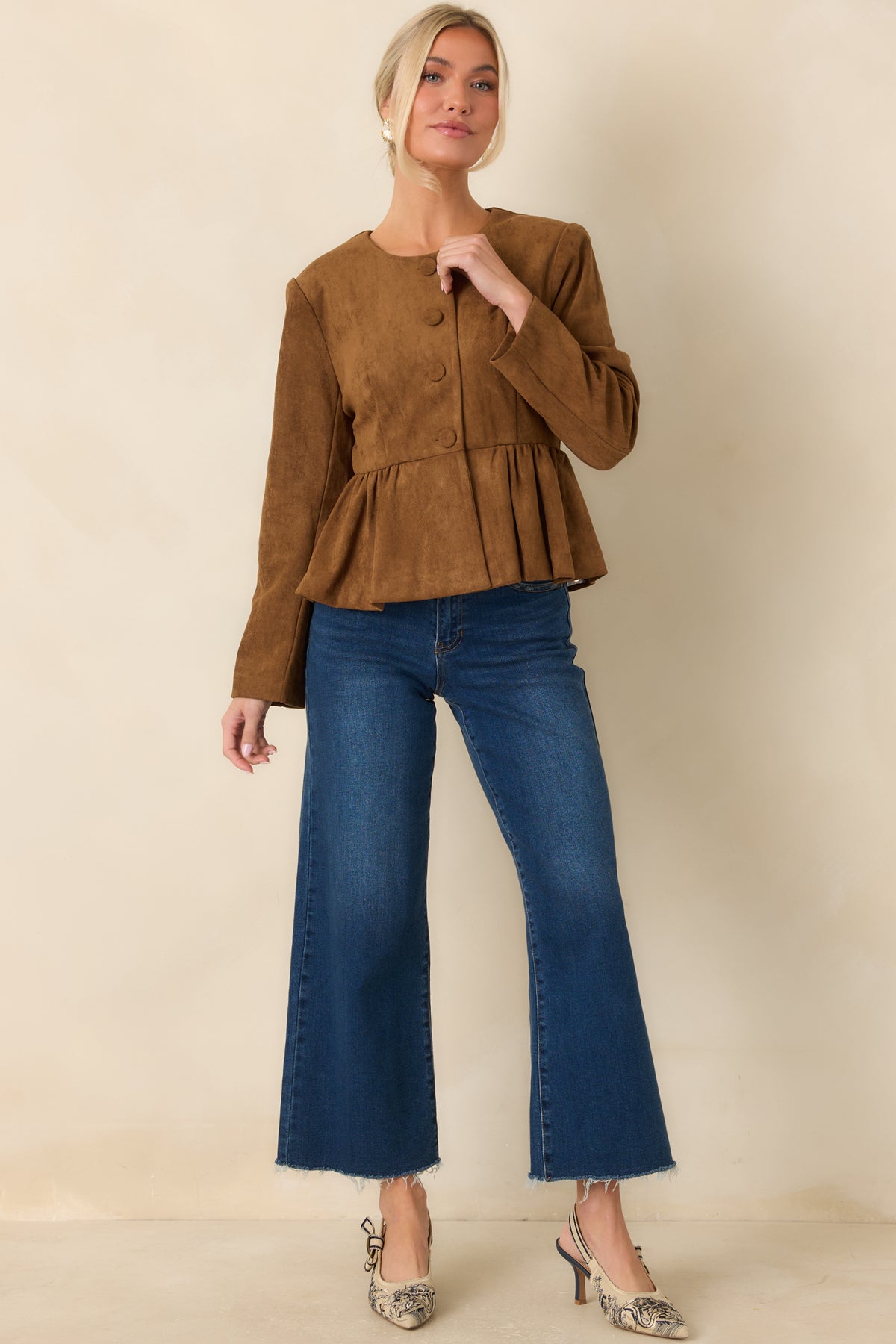 Fitted faux suede top with a collarless neckline, defined waist, and full button front.