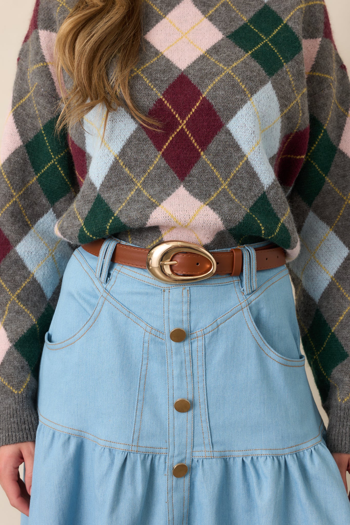 Warm cognac belt showcasing its smooth faux leather strap and statement gold-tone oval buckle with a polished finish.