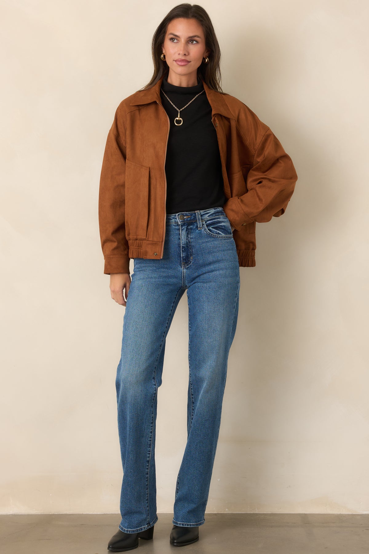 Cognac faux suede bomber with dropped shoulders, a classic pointed collar, front pockets, and zip closure.