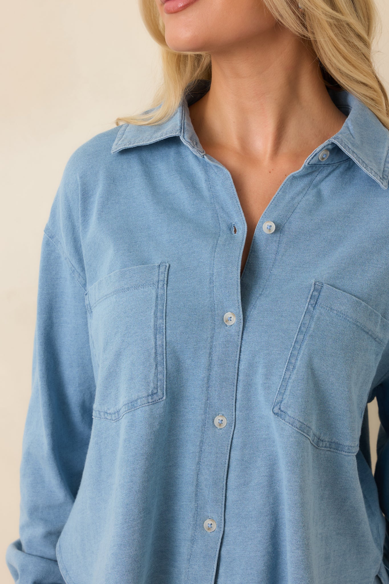 Close-up detail of the collar, buttons, and front pocket accents on the cropped top.