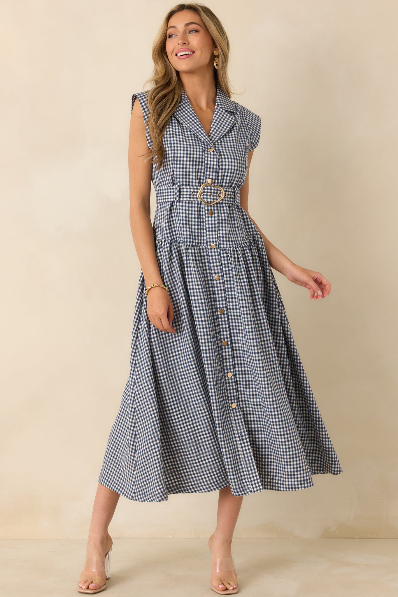 Collared navy gingham midi dress with sleeveless cut, full button closure, and relaxed A-line midi silhouette.
