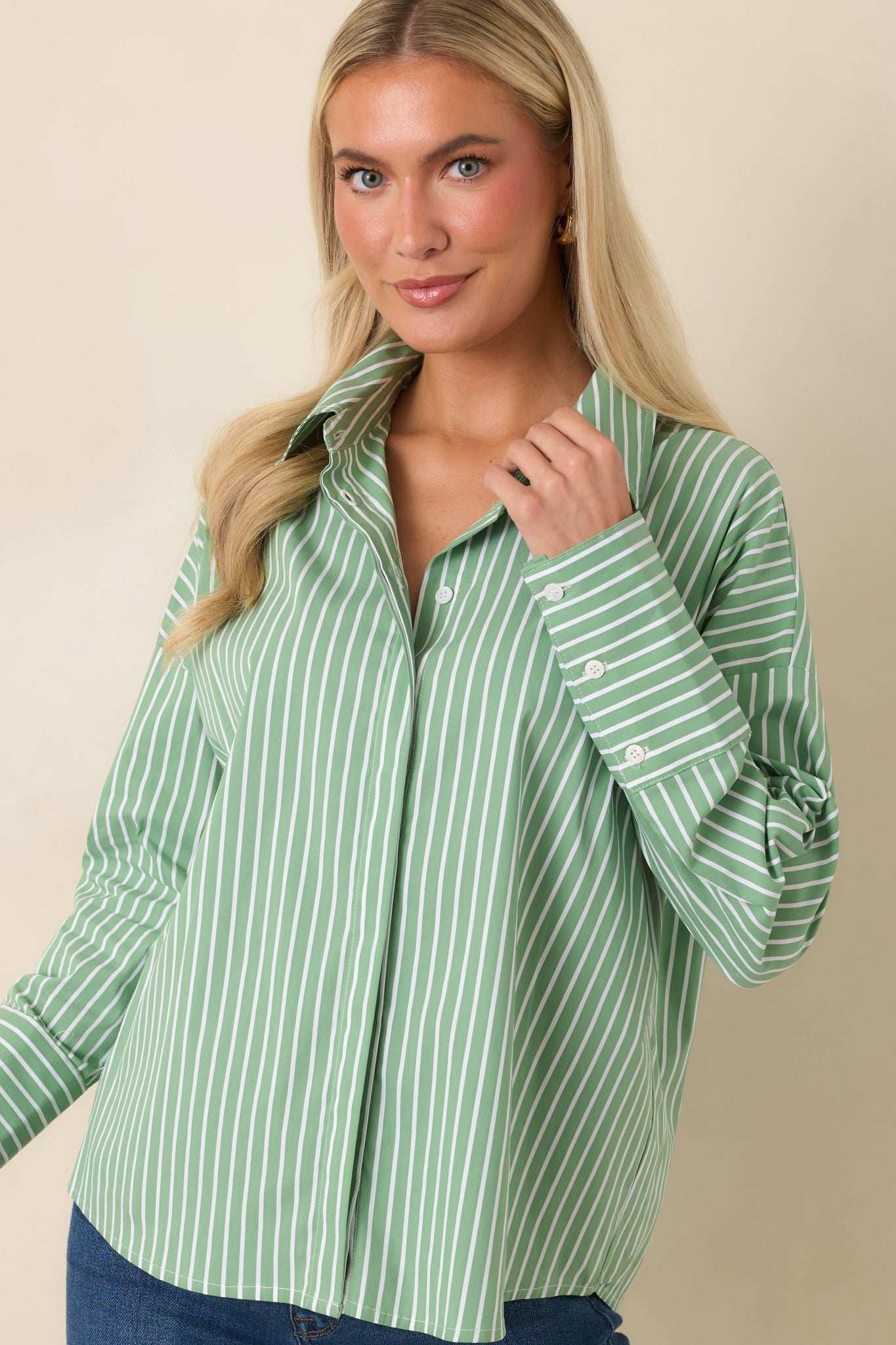 Close view of the collared neckline and button-front closure on the mint striped cotton shirt.