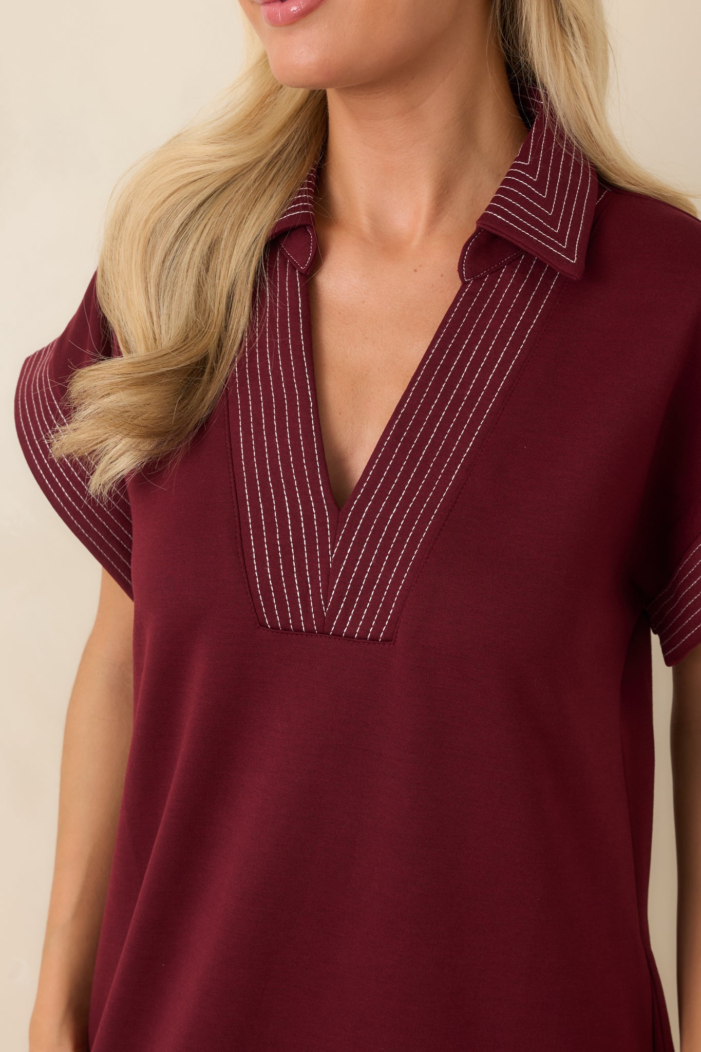 Close-up detail of the collared V-neckline, fabric texture, and front design of the dress.