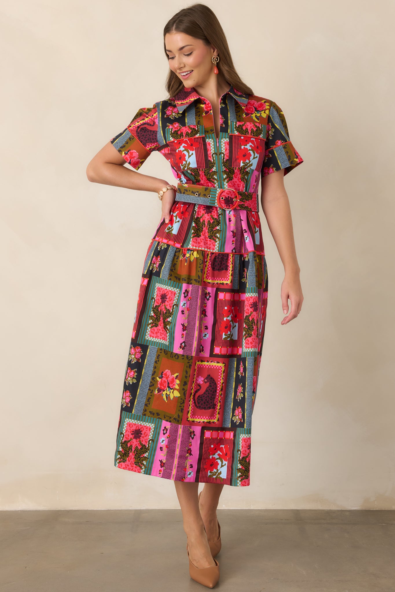 Collected-print dress with floral and framed motifs arranged across a tiered A-line skirt, finished with a matching belt, contrast piping, and tailored collar.